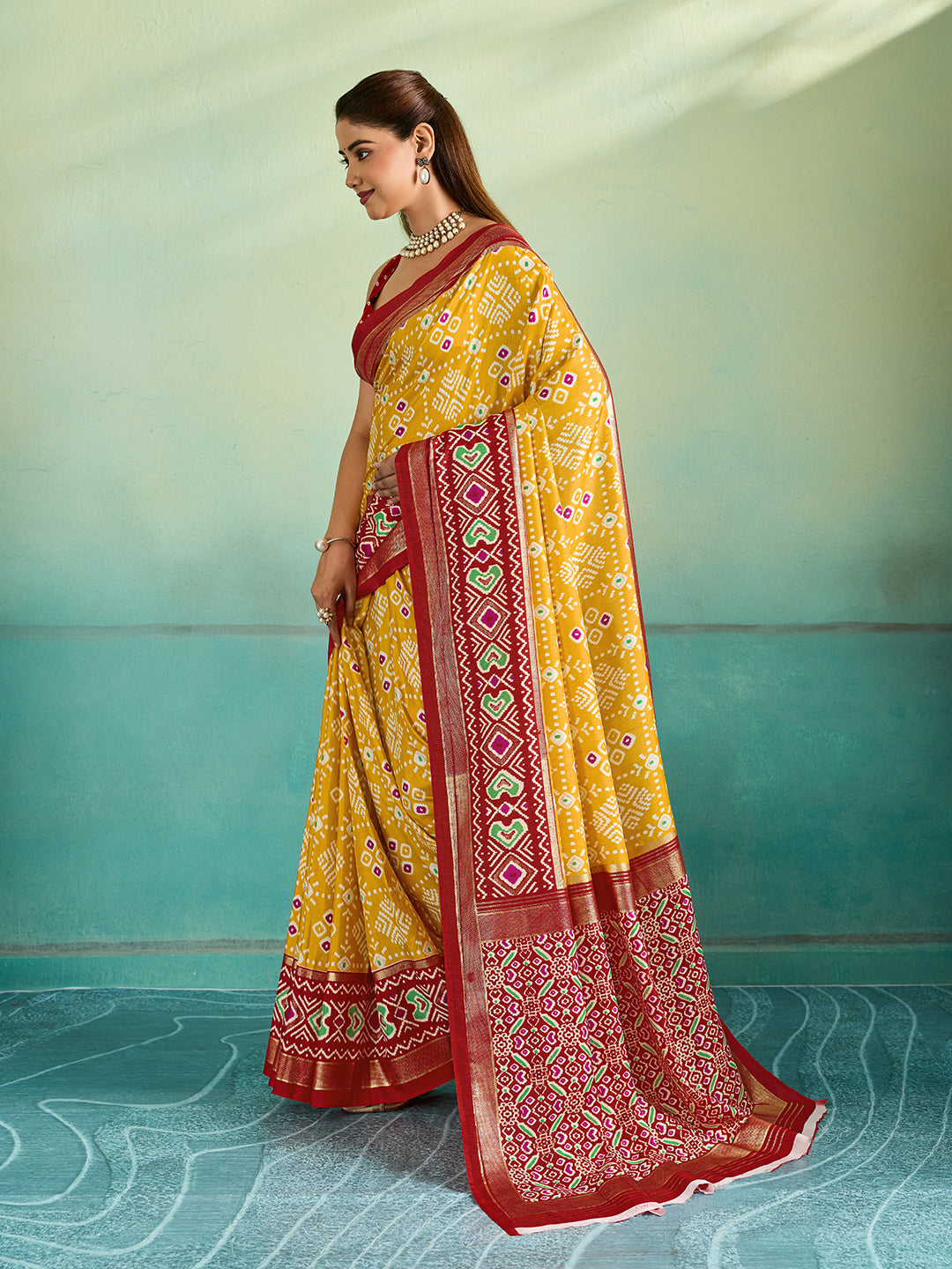 A yellow and red pashmina cotton silk saree with a patola style pattern