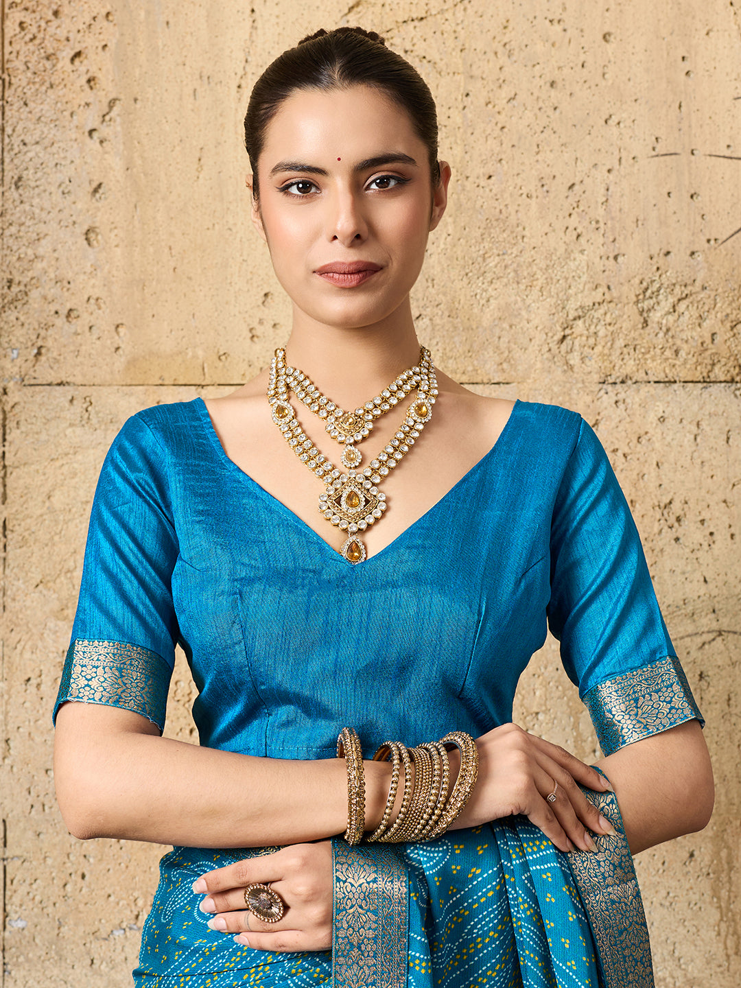A blue chiffon georgette saree with bandhani print, featuring a sky blue color and decorative patterns, paired with a blue blouse.
