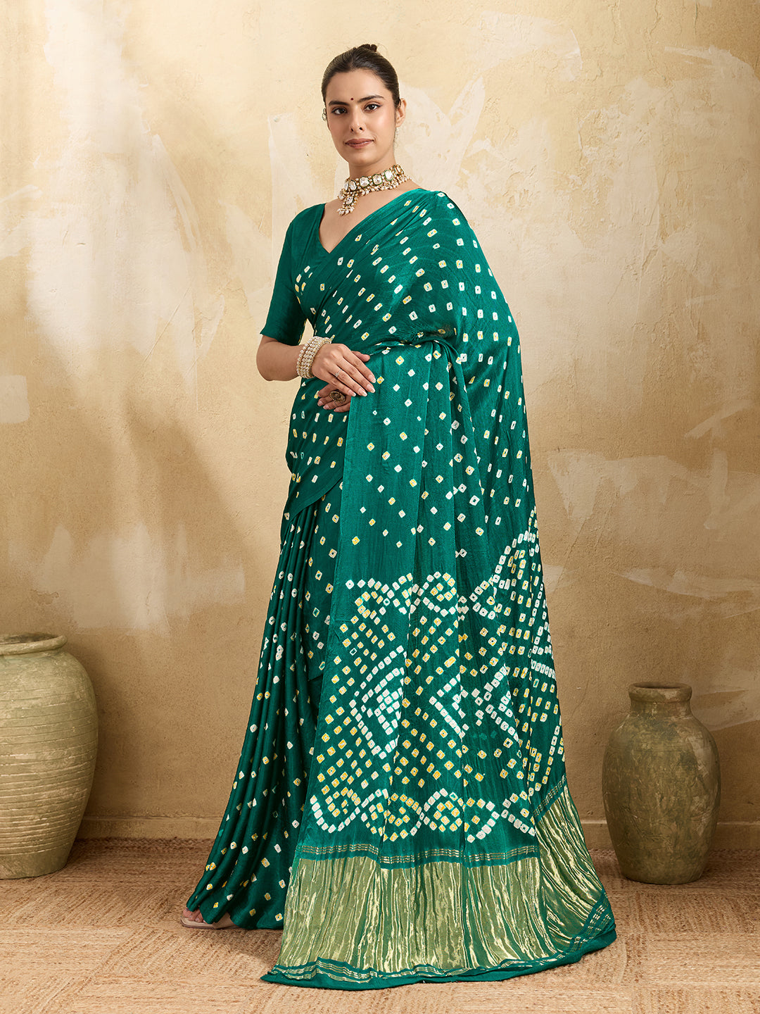 A traditional saree with a bandhani pattern in teal color,