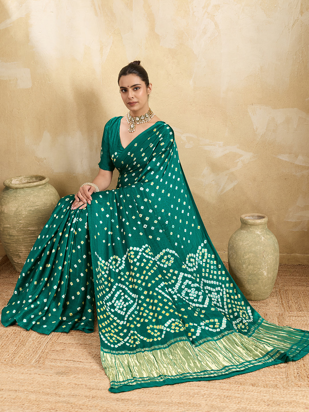 A traditional saree with a bandhani pattern in teal color,