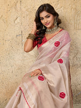 A white saree with red beads work and cutdana embellishments.