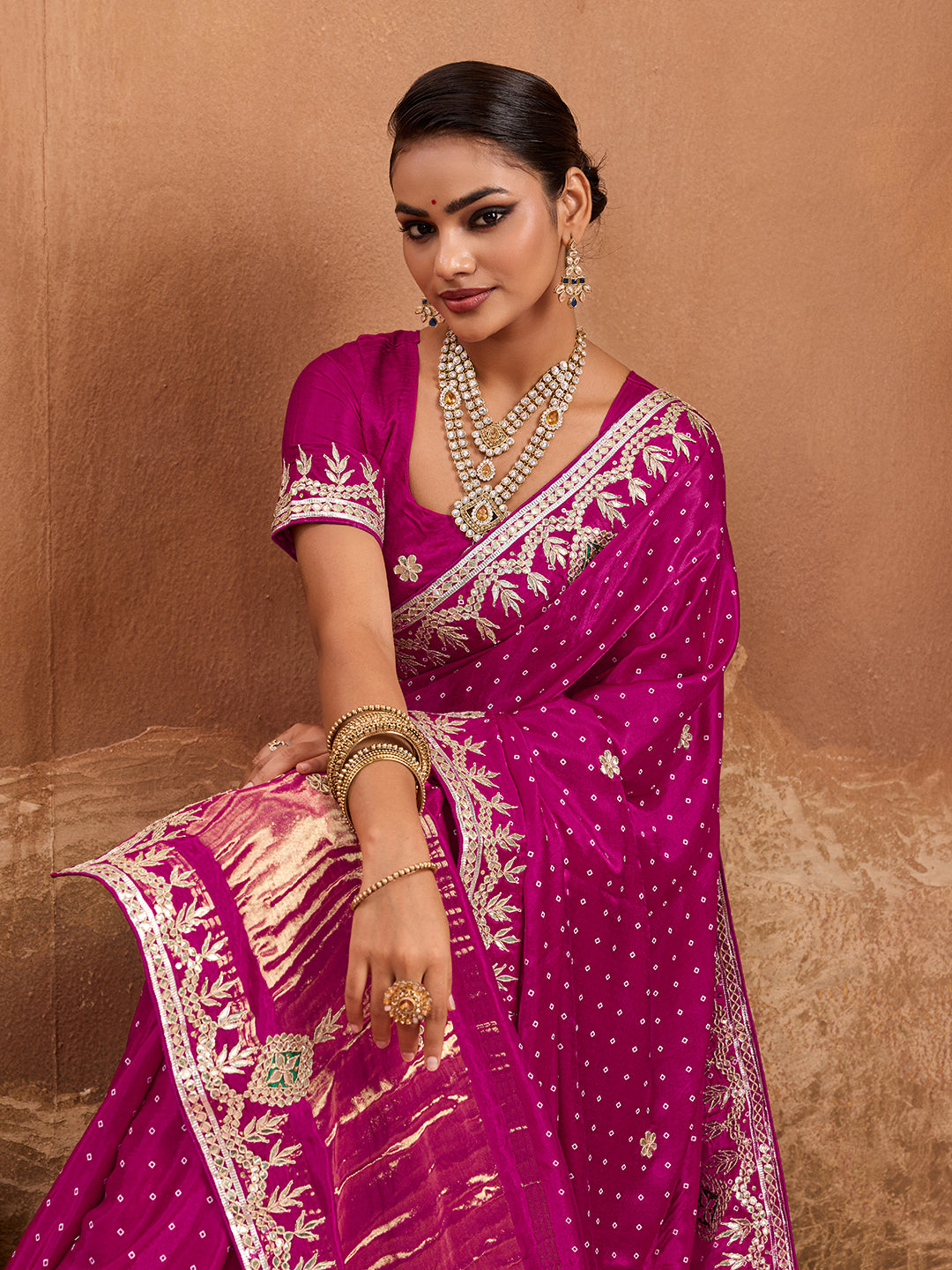 A pink modal silk saree with bandhani pattern and gotapatti work