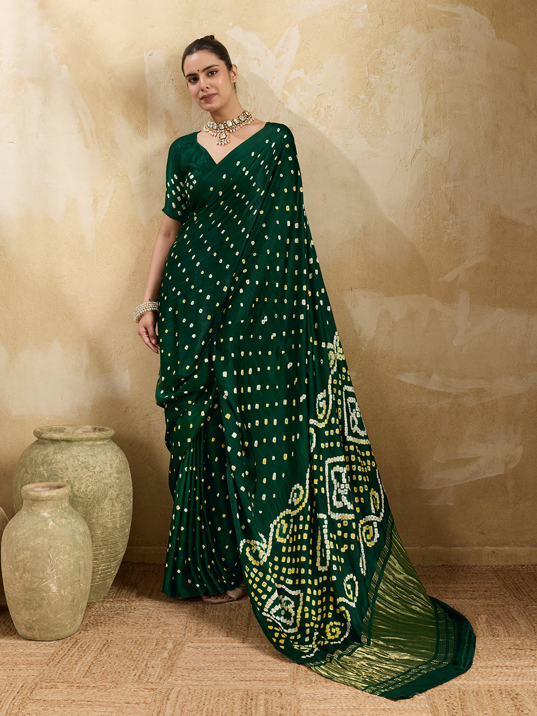 A bottle green saree with bandhani print and lagdi patola pallu, alongside a blouse piece.