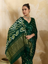 A bottle green saree with bandhani print and lagdi patola pallu, alongside a blouse piece.
