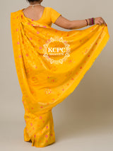 A yellow banarasi silk saree with floral patterns and zari embellishments.
