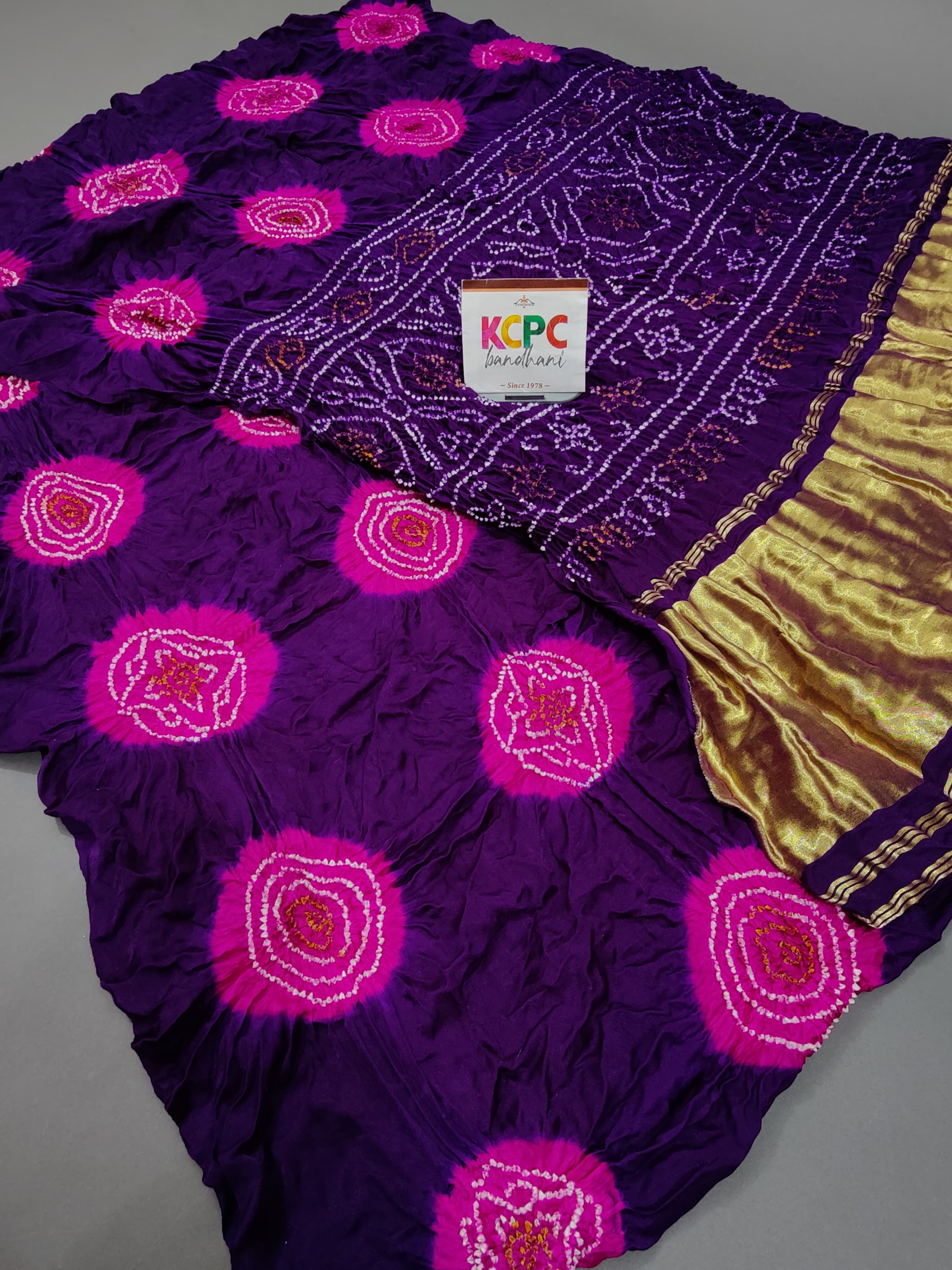 A purple silk saree with golden zari embellishments