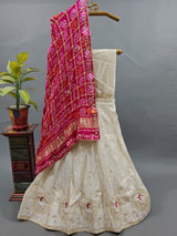 A traditional Indian lehenga with a dupatta, a pink and beige color
