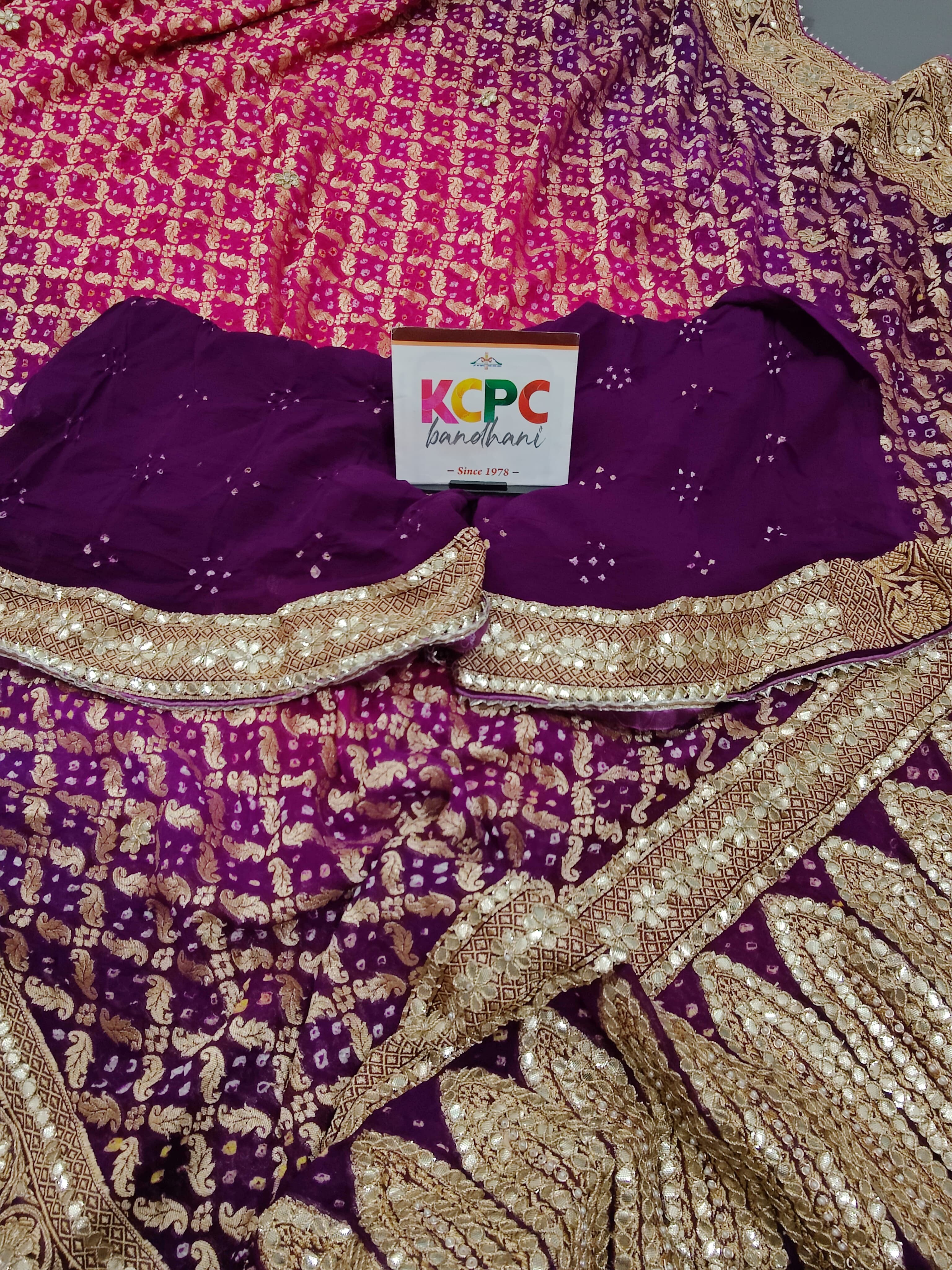 A designer pure khaddi georgette neemzari bandhej gotapatti zaridoji work saree in pink and purple colors
