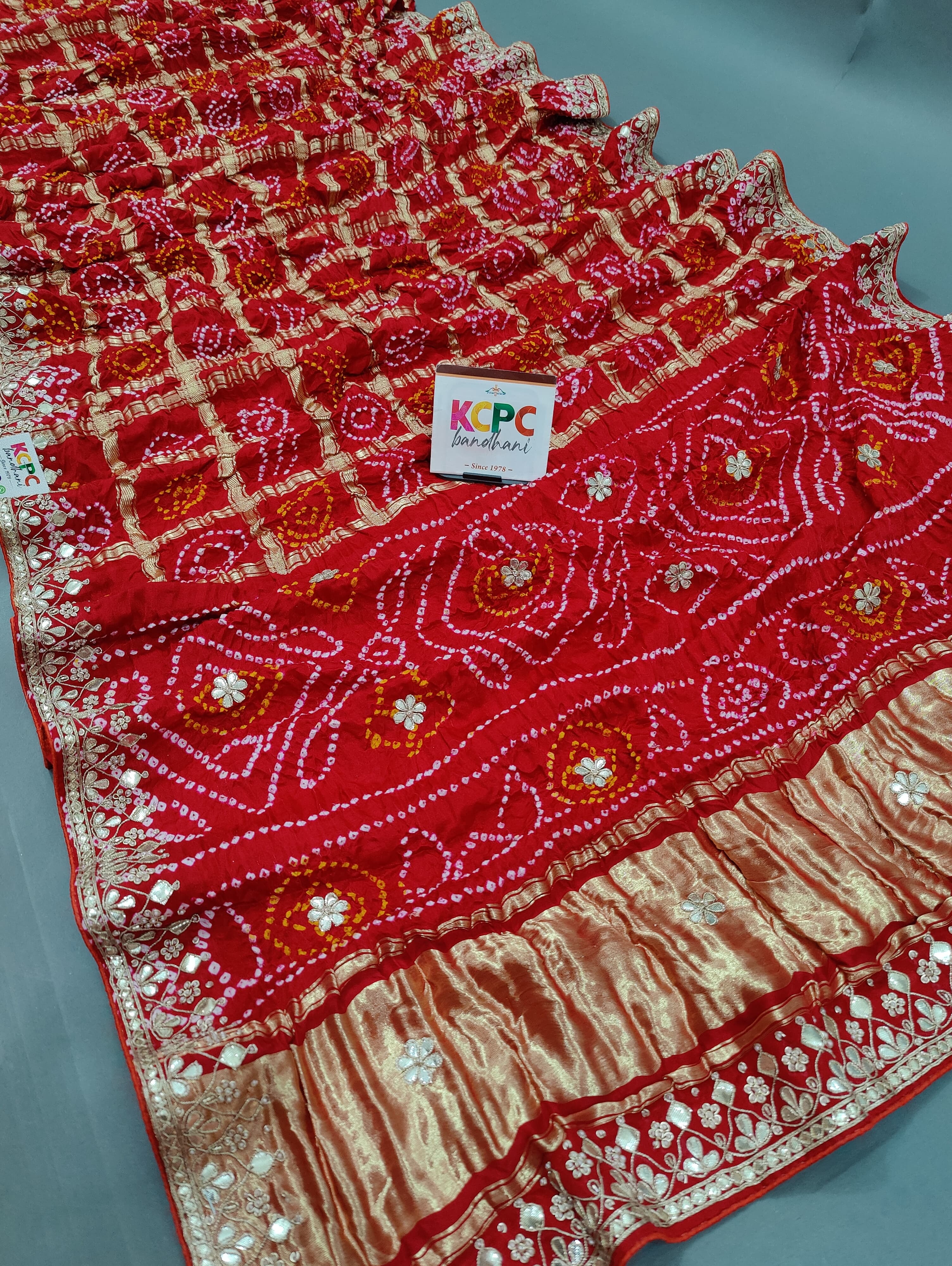A red silk saree with gota patti work