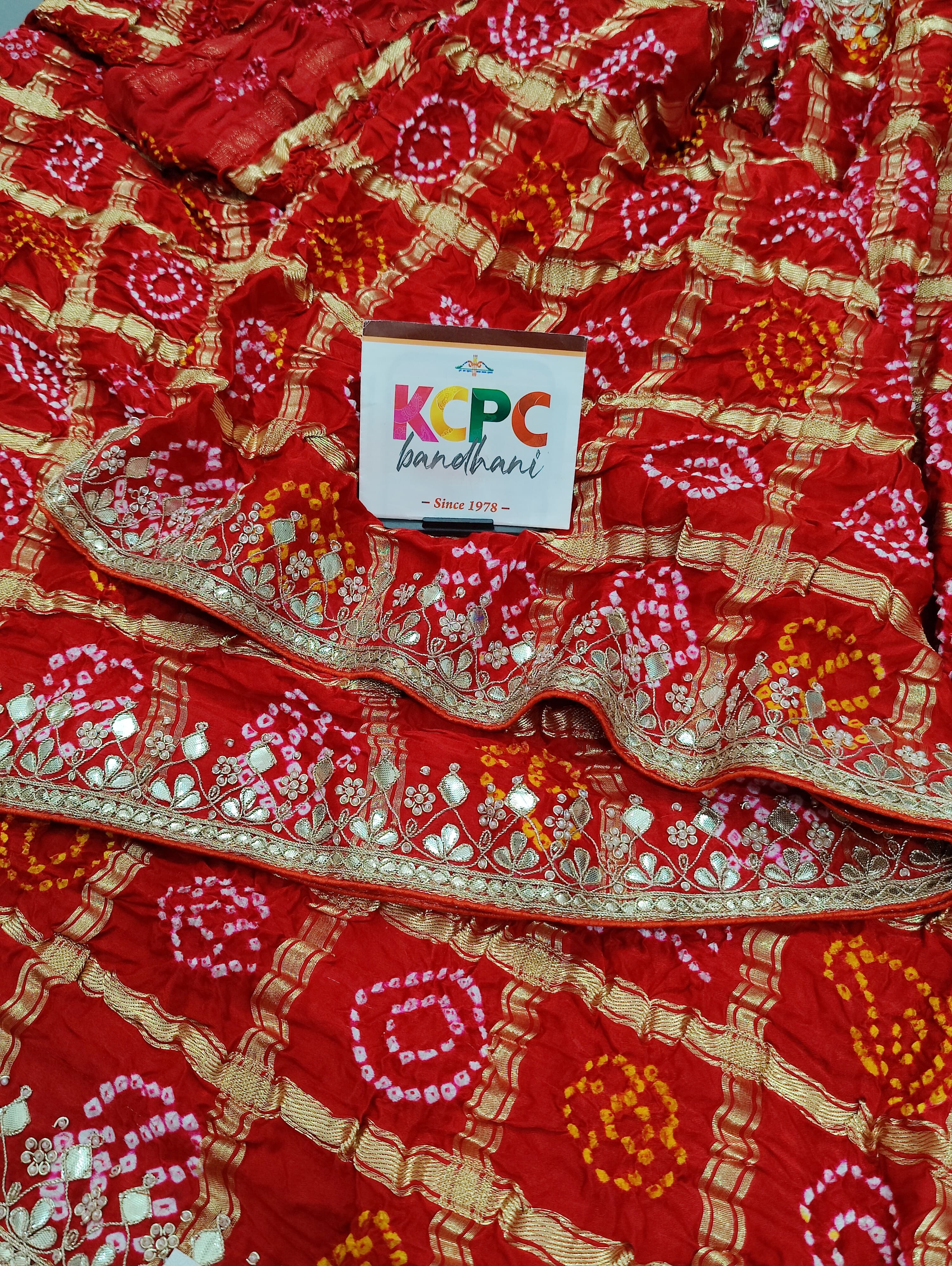 A red silk saree with gota patti work