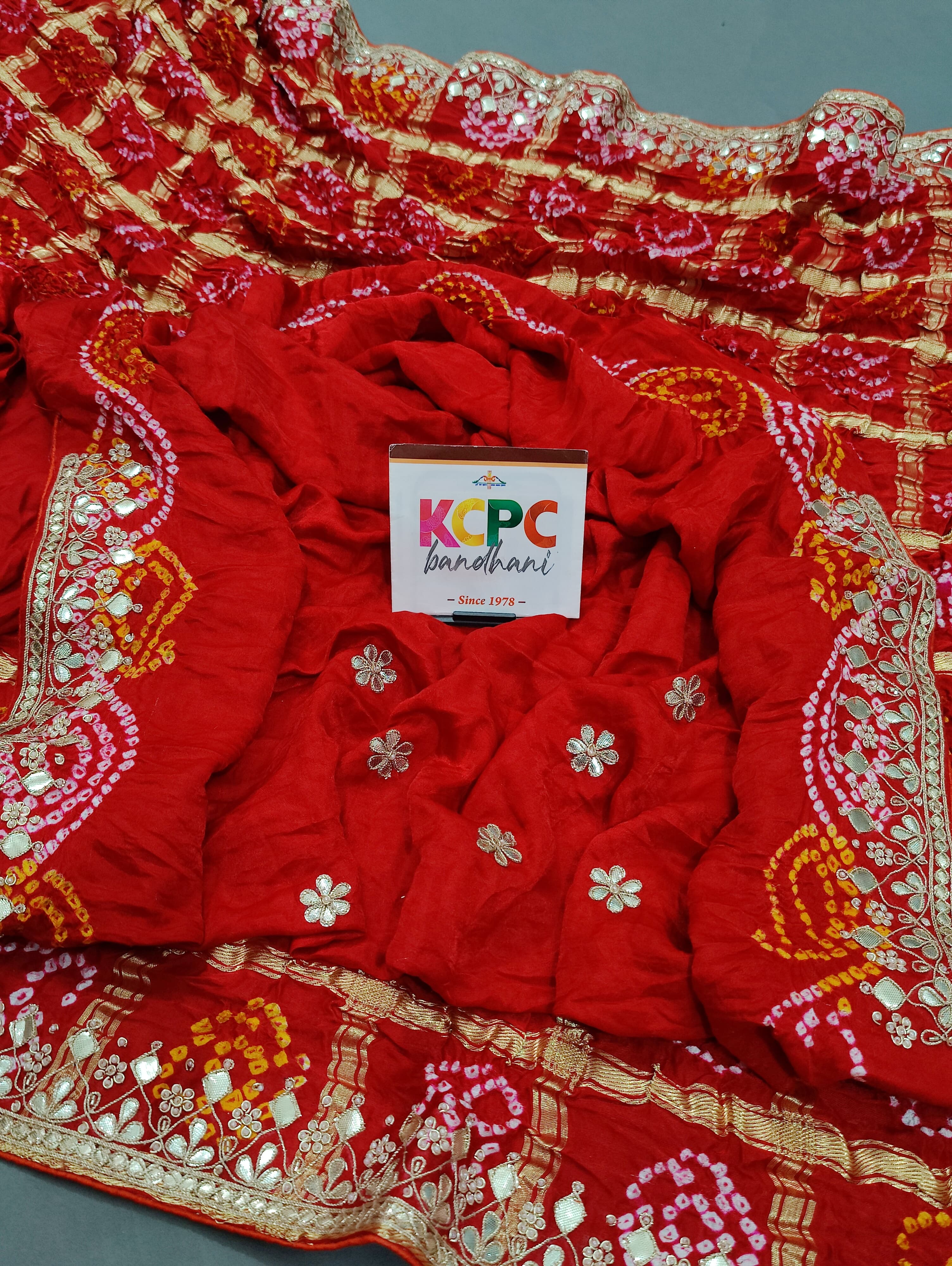 A red silk saree with gota patti work