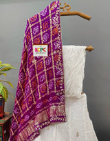 A traditional Indian lehenga set and purple dupatta with gotapatti work.