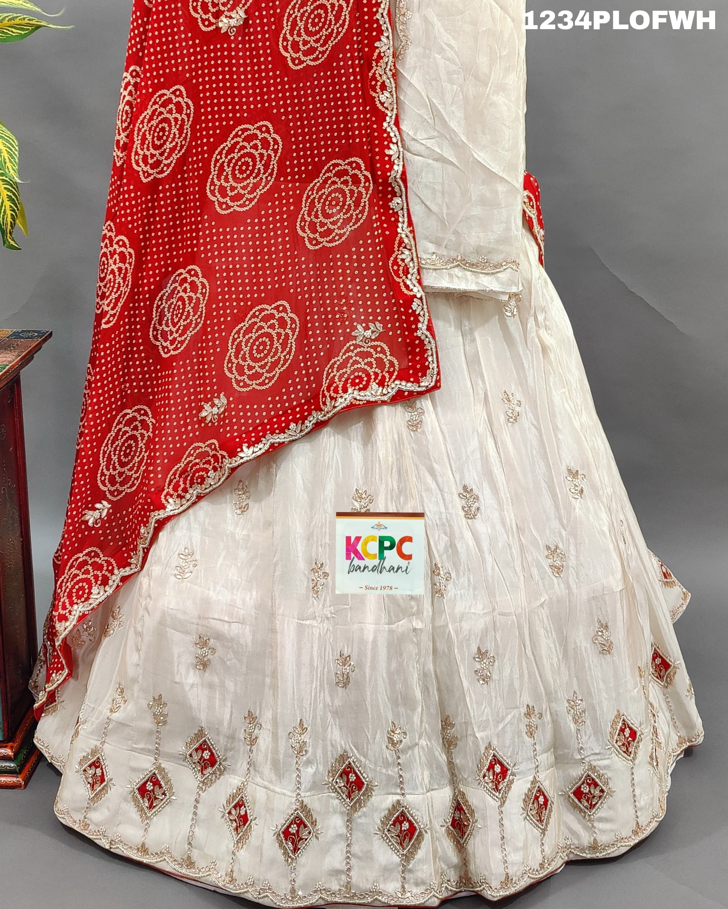 A red and white traditional lehenga set with dupatta and gota work