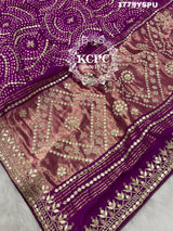 A purple and pink bandhani saree with heavy gotapatti work