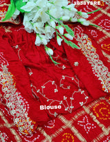 A red and gold saree with floral patterns and gota patti embellishments