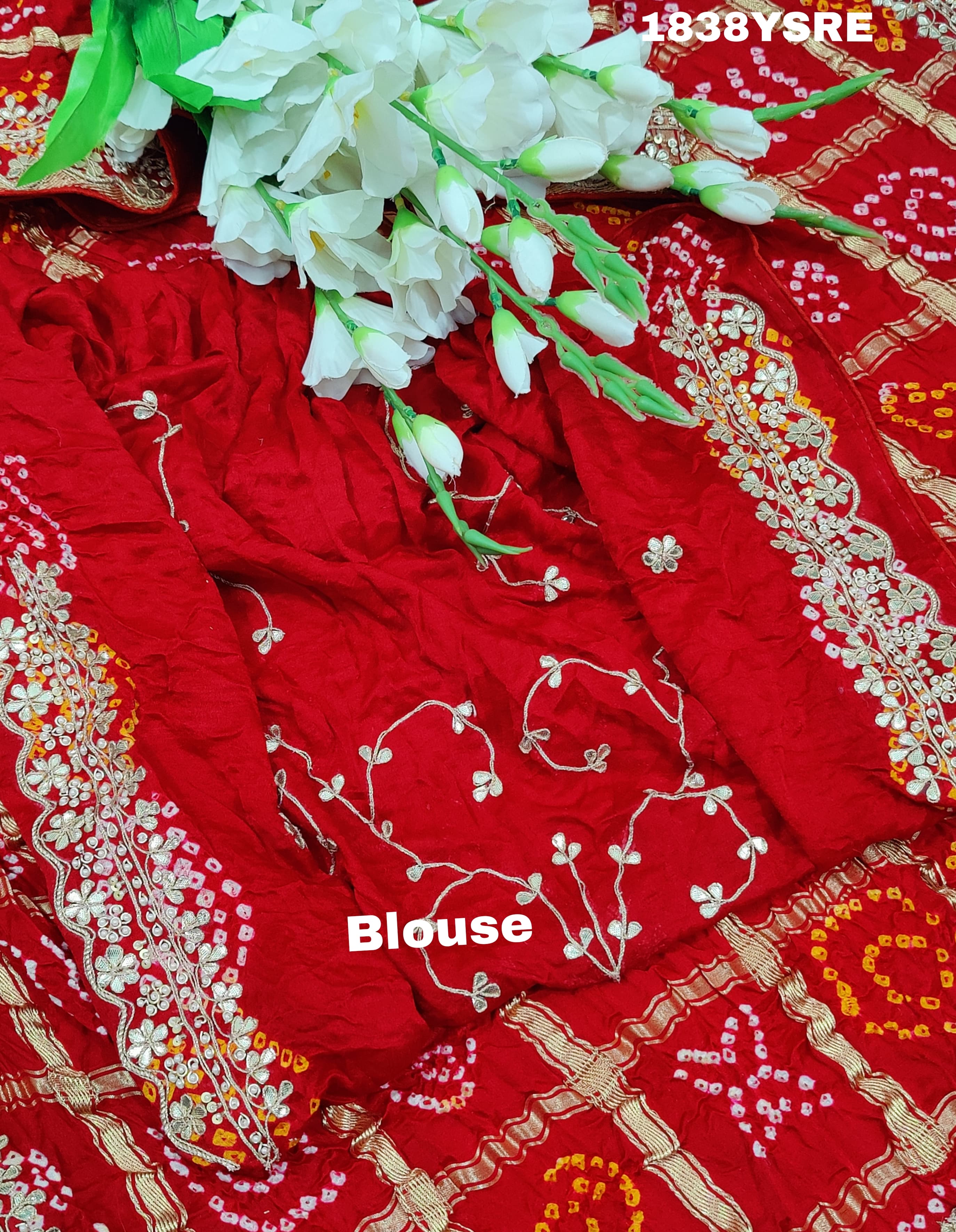 A red and gold saree with floral patterns and gota patti embellishments