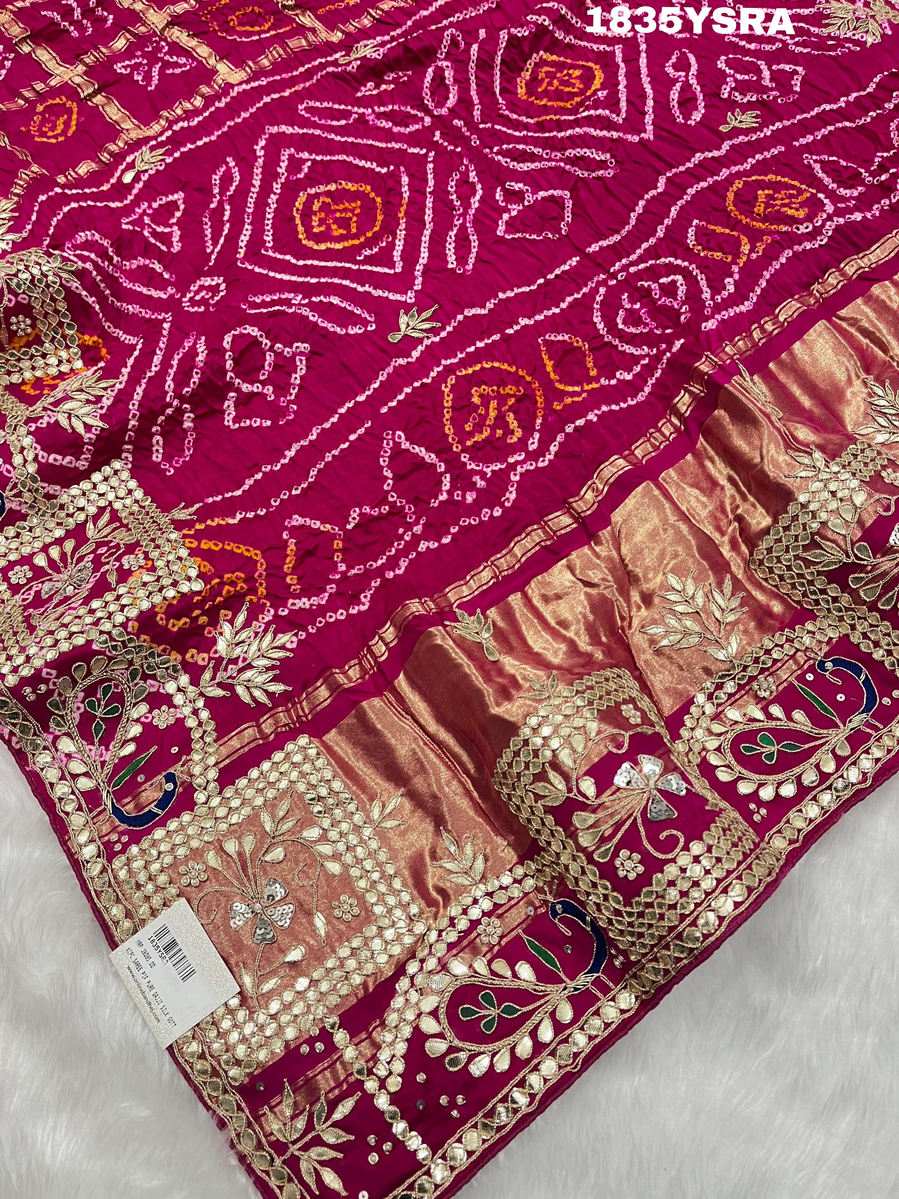 A pink and red silk saree with gota patti work and a floral embellishment