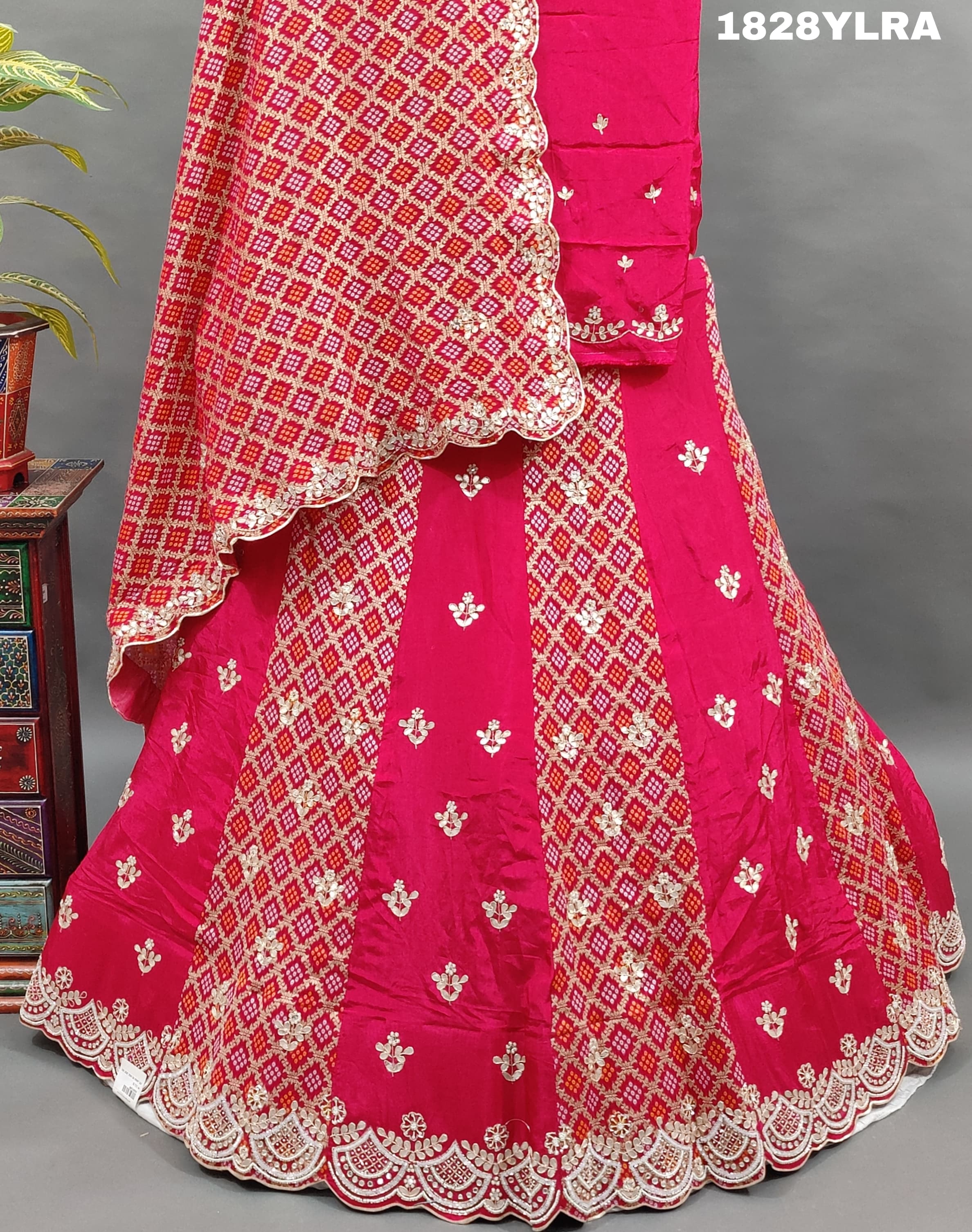 A traditional wear lehenga set with bandhani print and white bead work