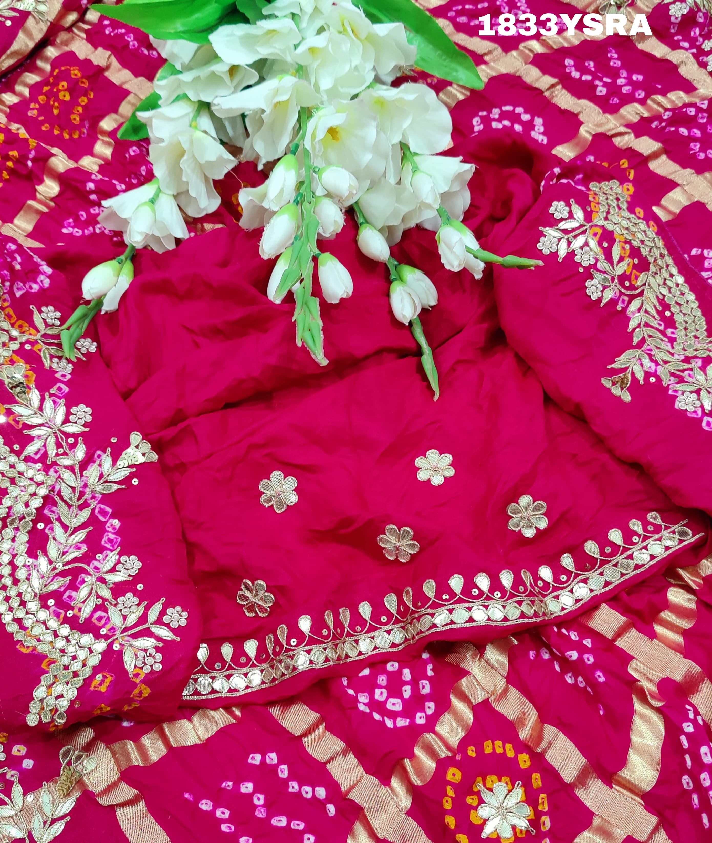 A pink saree with detailed golden and silver gotapatti work and a floral design