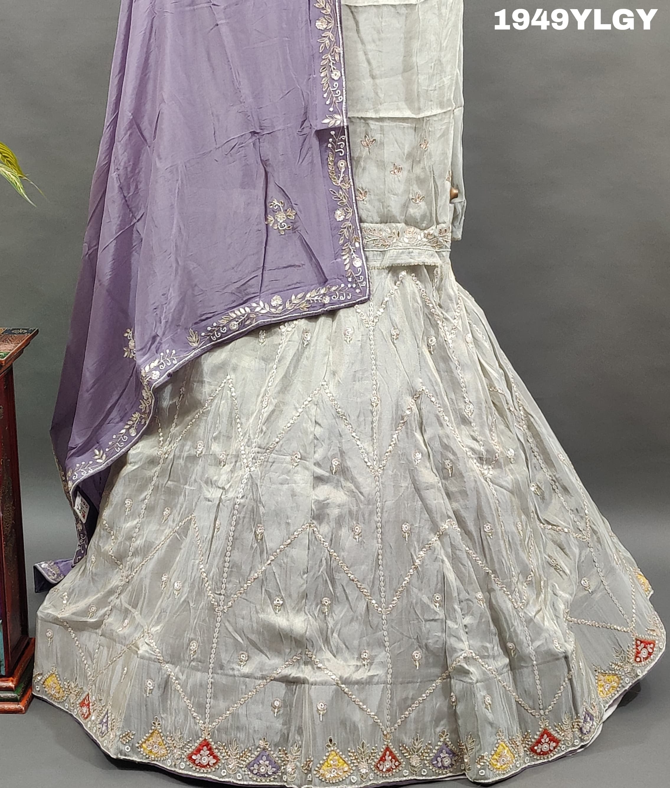 A traditional Indian lehenga set with white beadwork and a pastel pink Banarasi silk