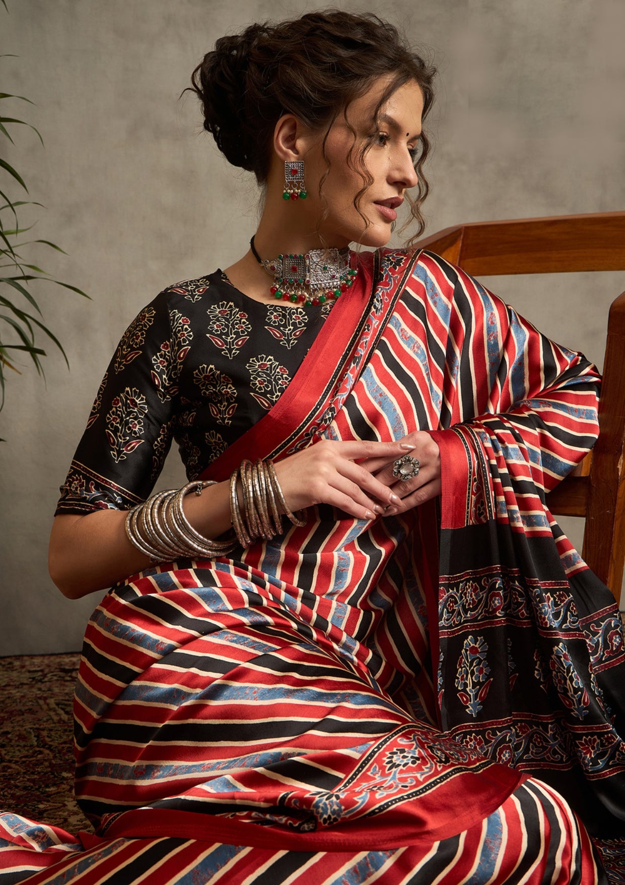 A traditional saree with a geometric ajrak print in red and black colors