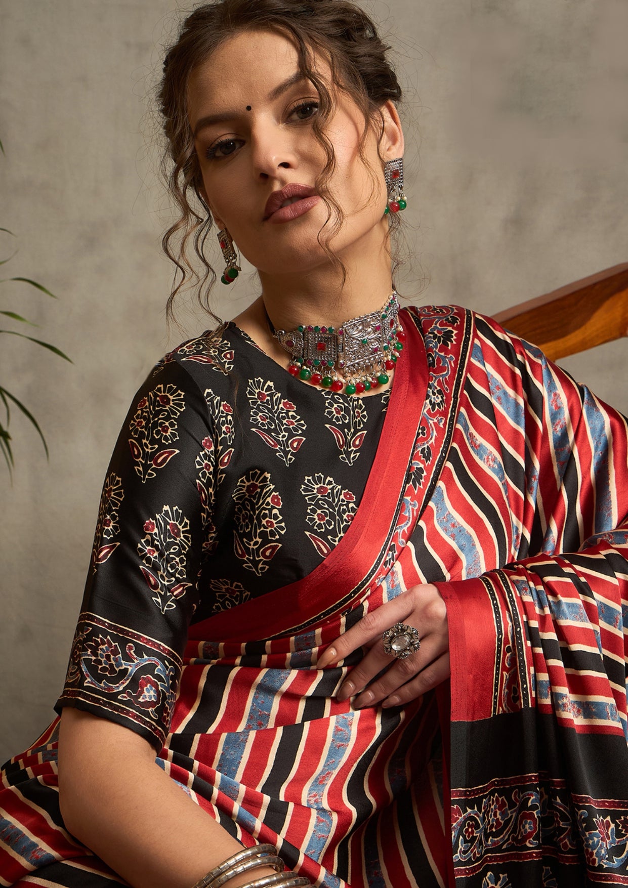 A traditional saree with a geometric ajrak print in red and black colors
