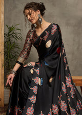 A black silk saree with red and blue ajrak print design and a golden border.