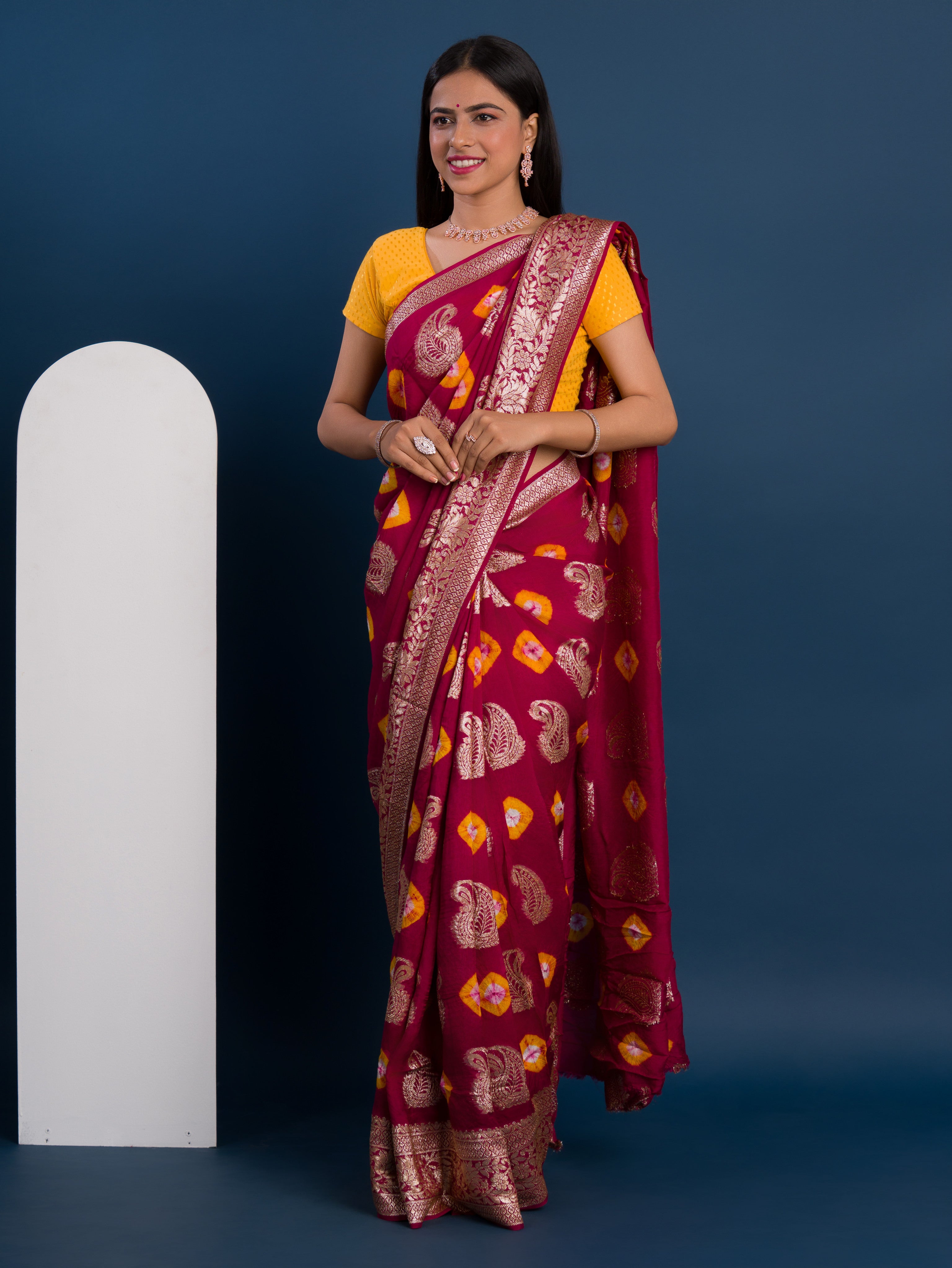 A maroon saree with gold patterns withDola Silk Bandhani Zari Weaving Work