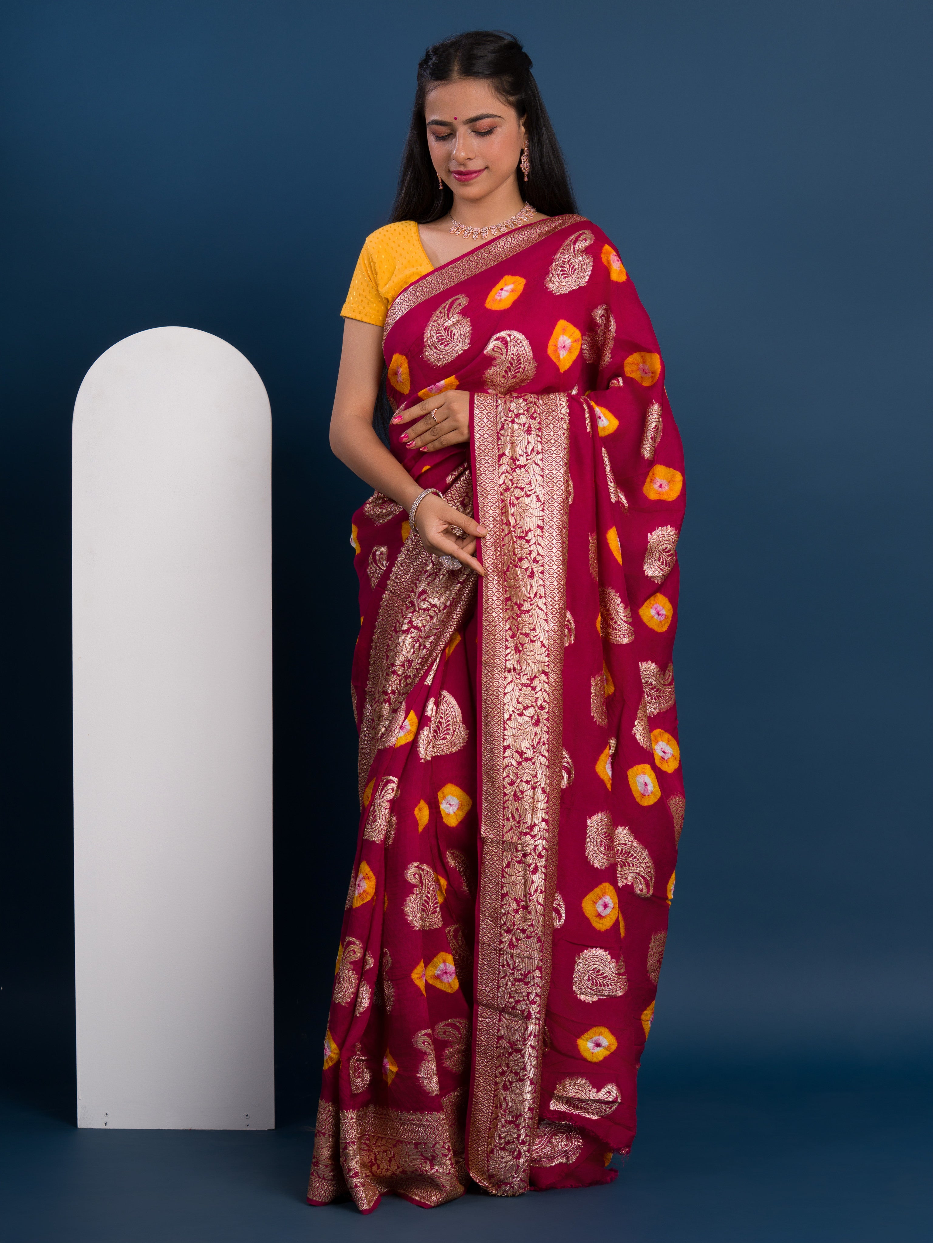A maroon saree with gold patterns withDola Silk Bandhani Zari Weaving Work