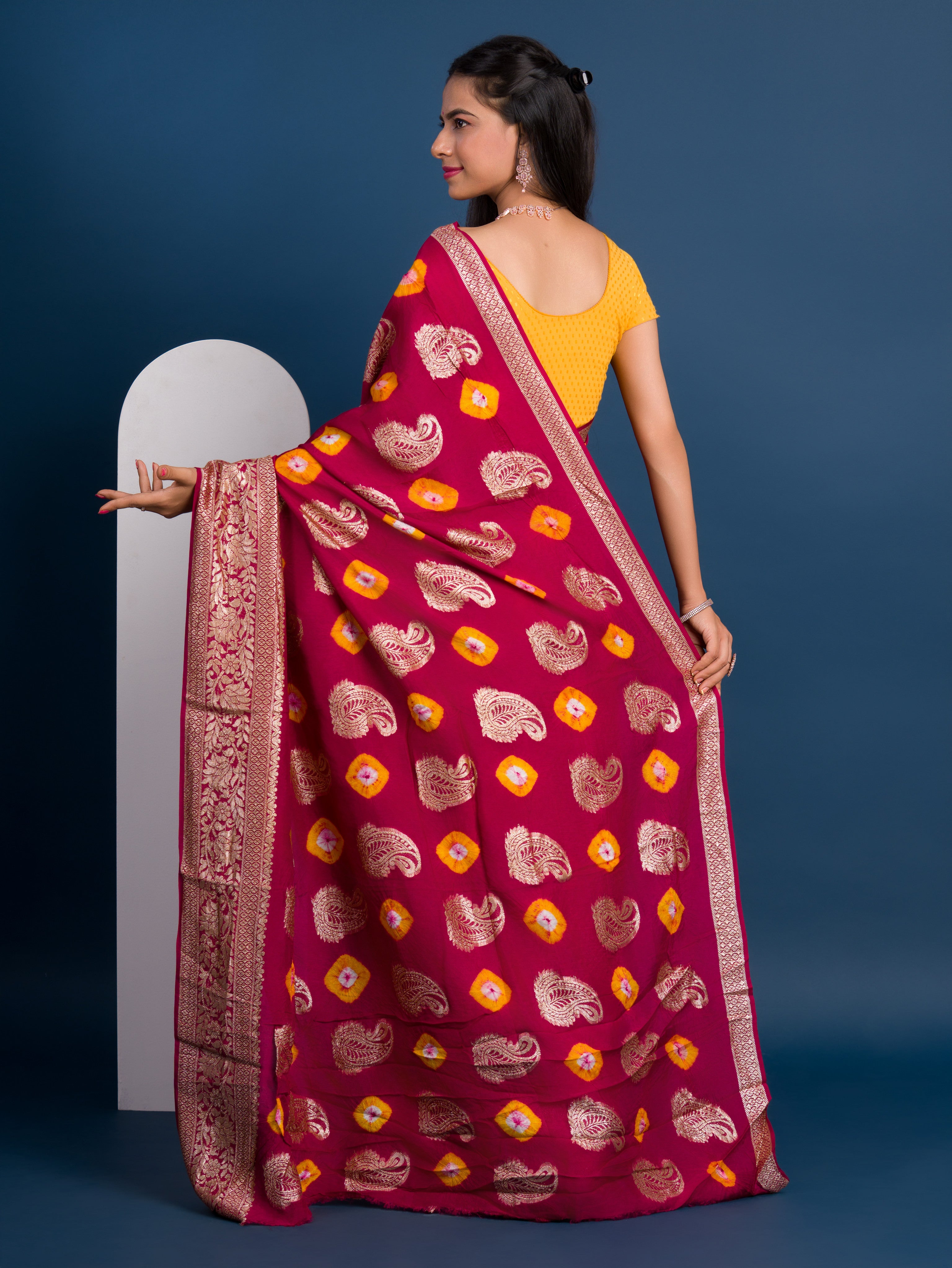A maroon saree with gold patterns withDola Silk Bandhani Zari Weaving Work