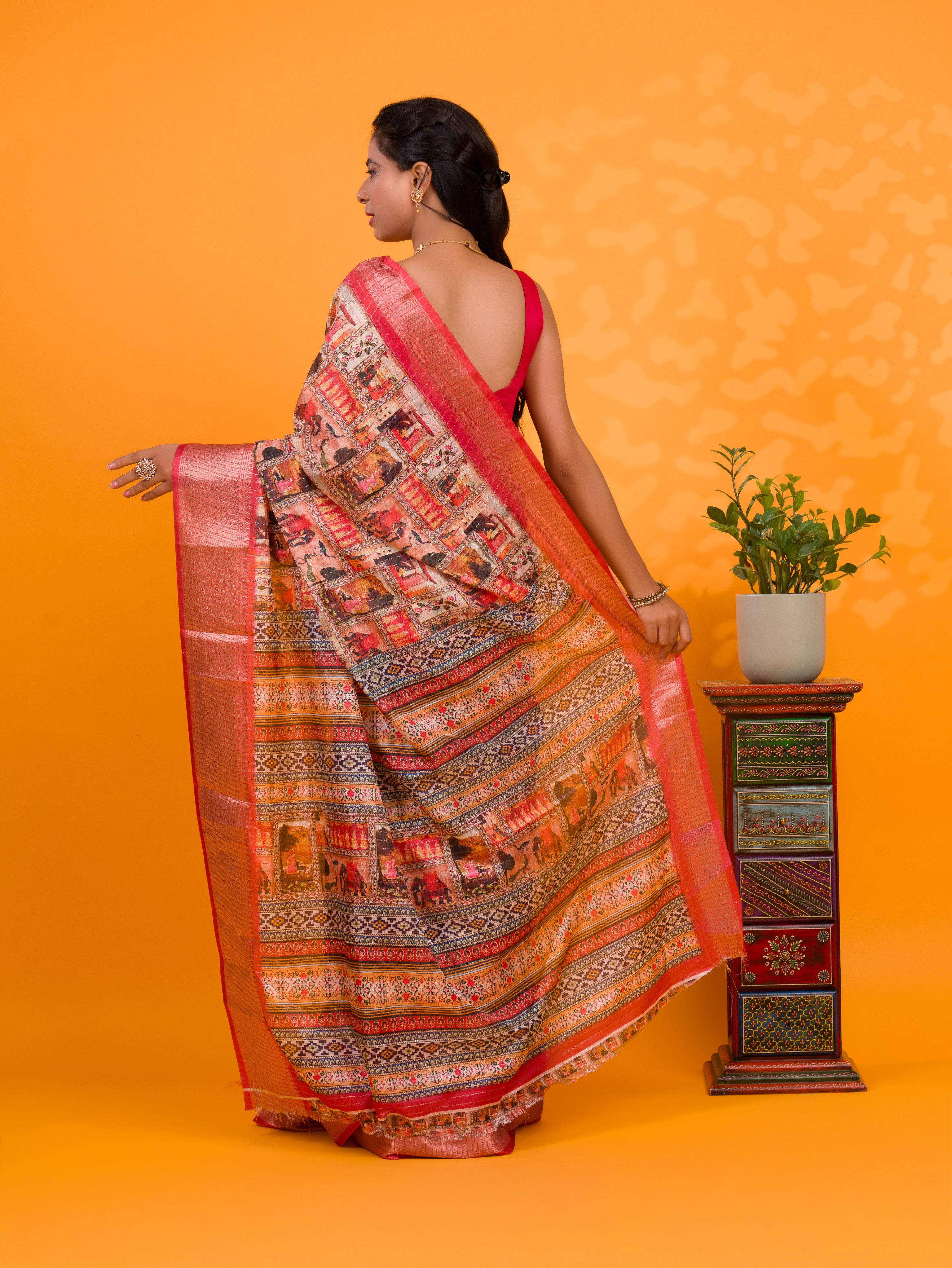 A saree with a kalamkari style pattern in red colors, with zari weaving and a Banarasi border. under 1000