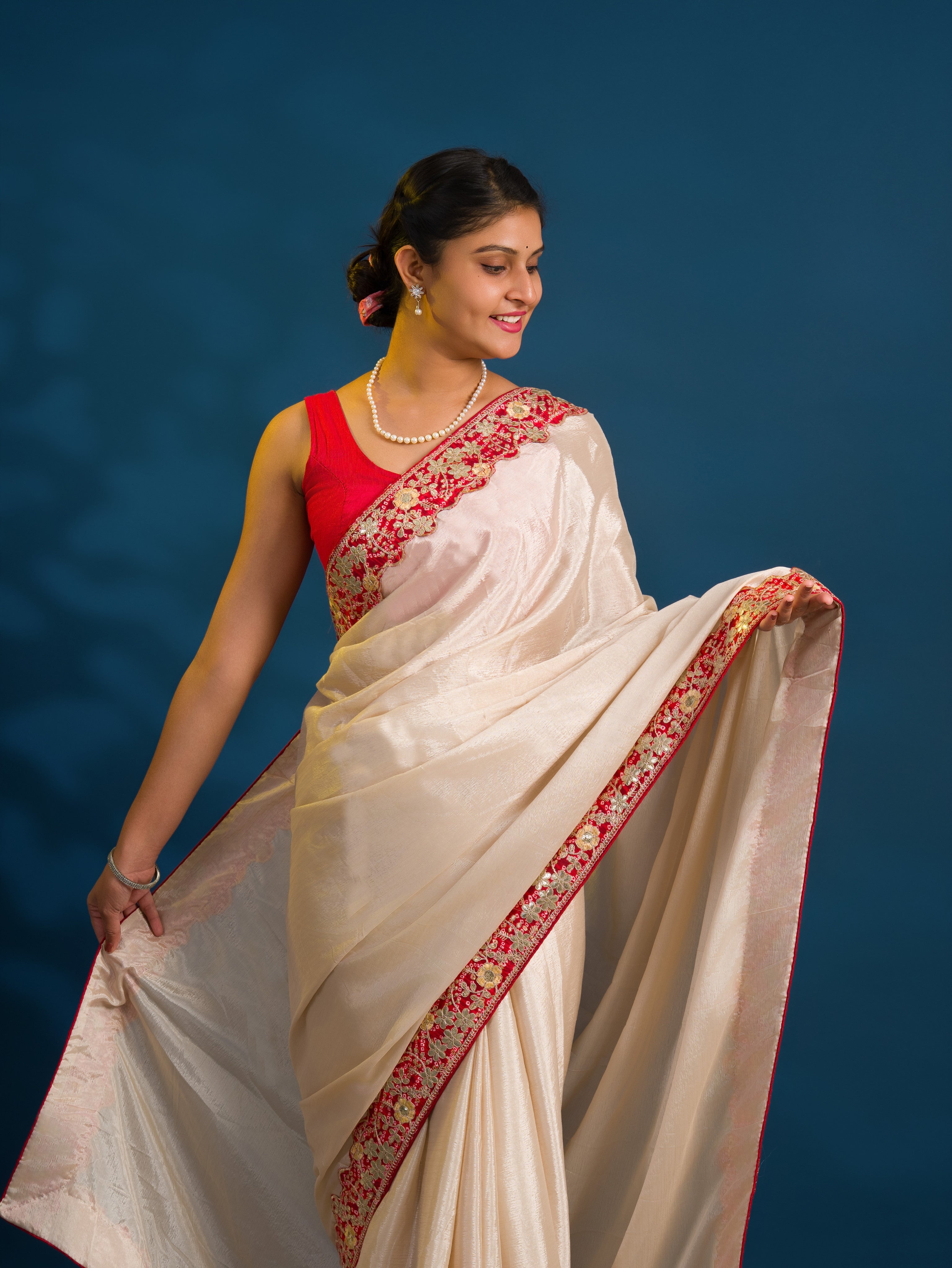 A white chinon silk Bollywood style saree with embellishments and gotapatti work