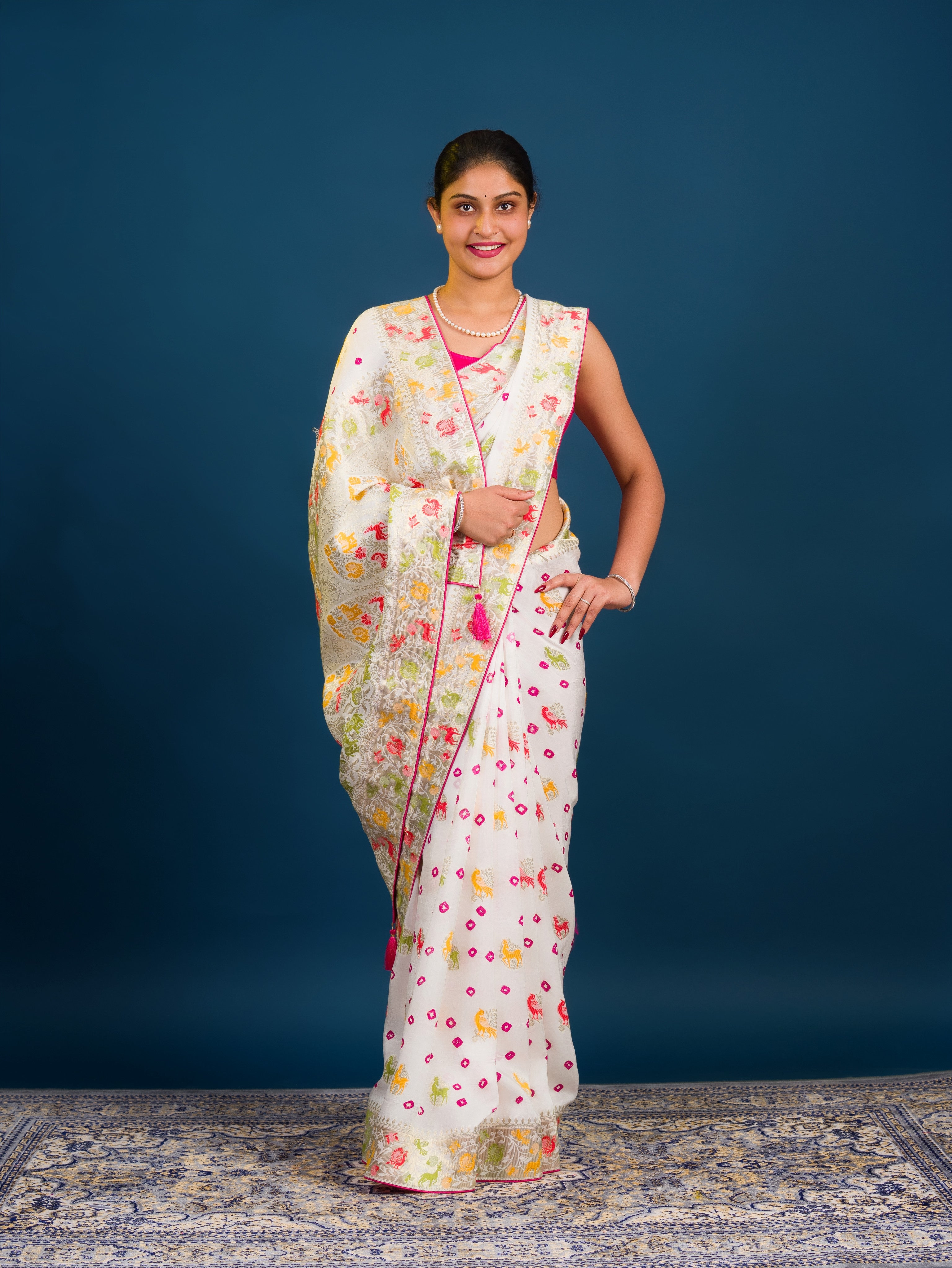 A Chinon silk saree with a Kalamkari style pattern, featuring a white base with multicolored floral designs and zari weaving details