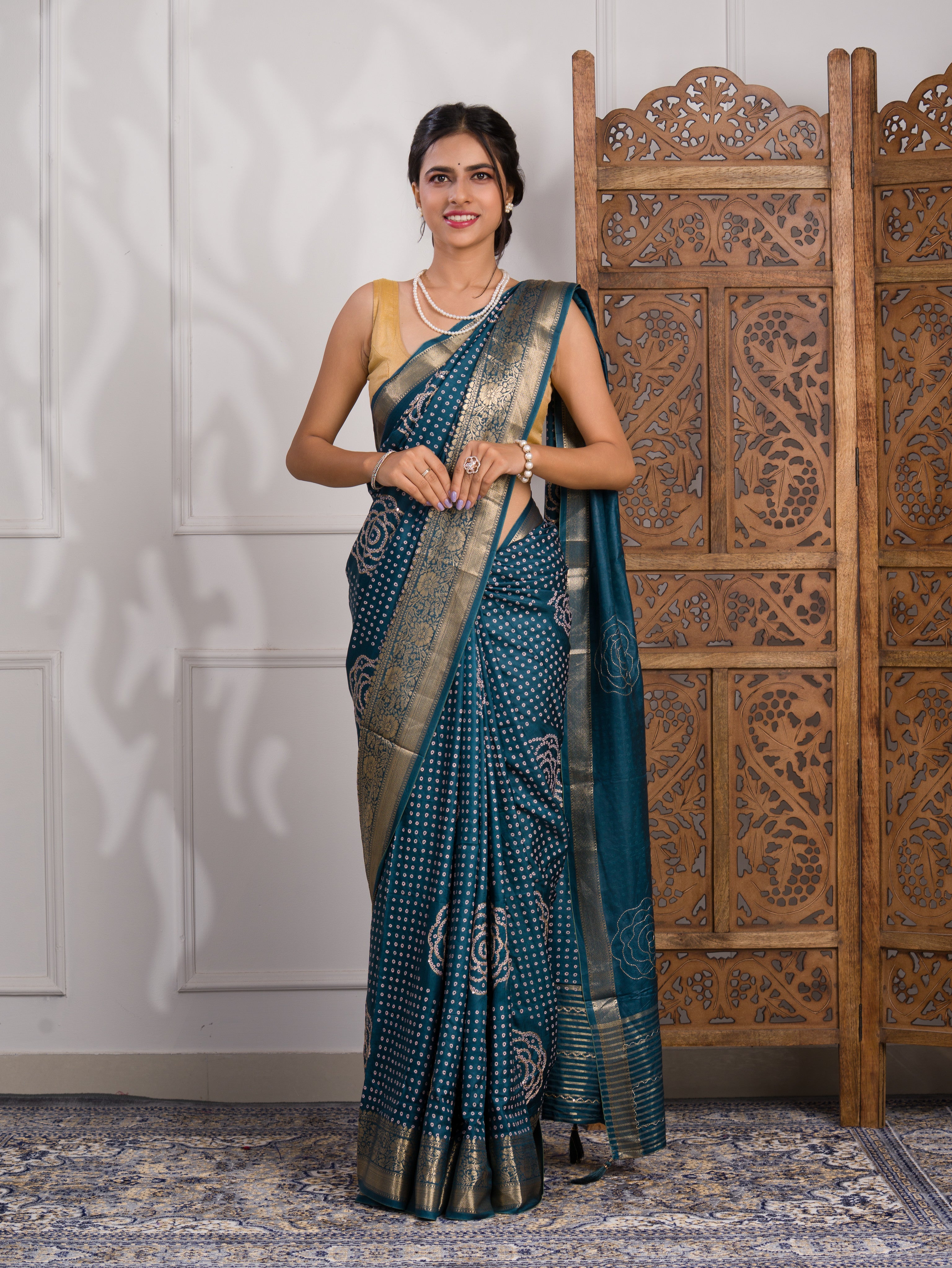 A blue saree with bandhani style embellishments and zari work