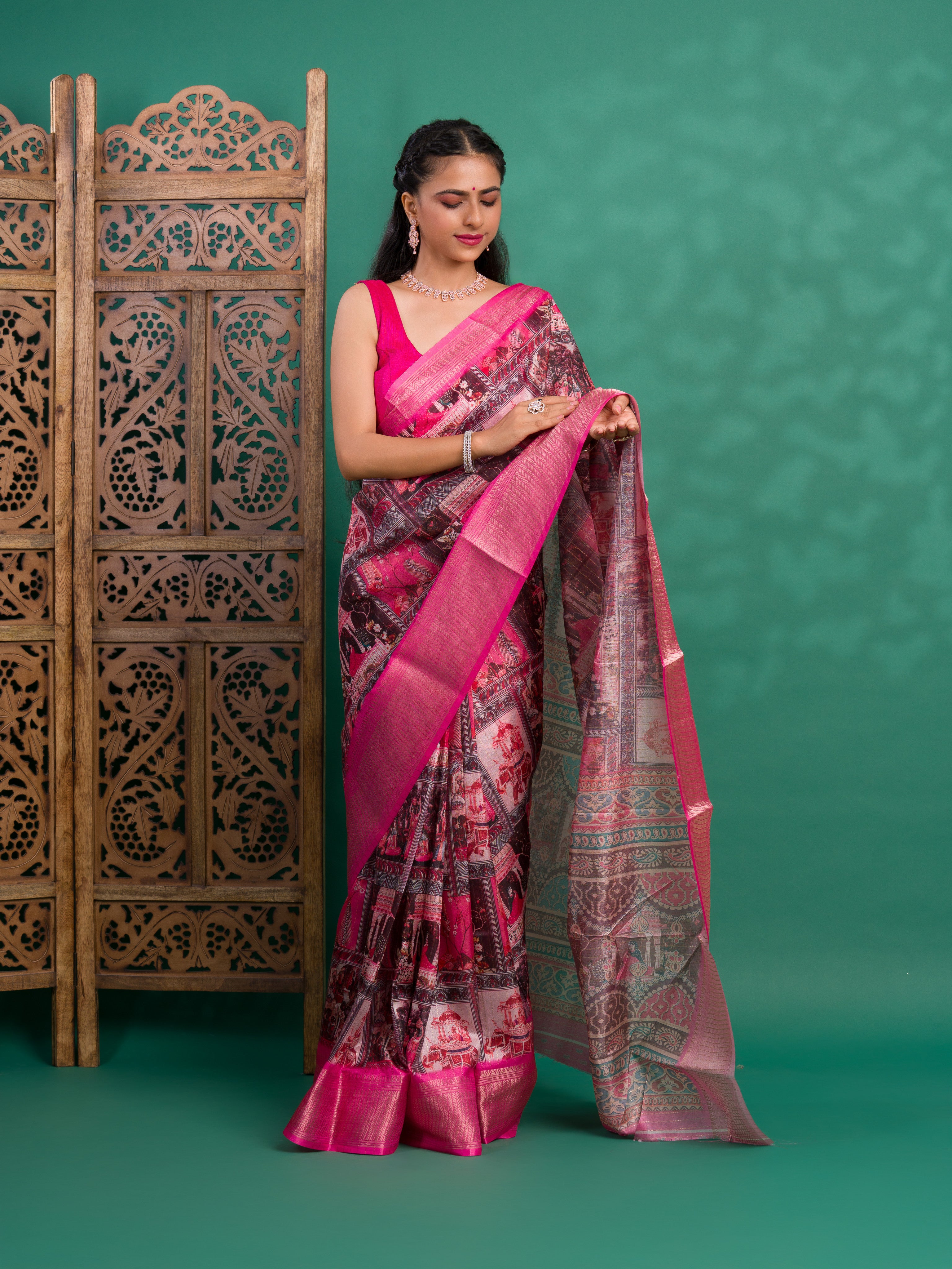 A saree with a kalamkari style pattern in pink colors, with zari weaving and a Banarasi border.