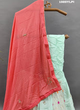 A lehenga set with a green and pink color cutdana work