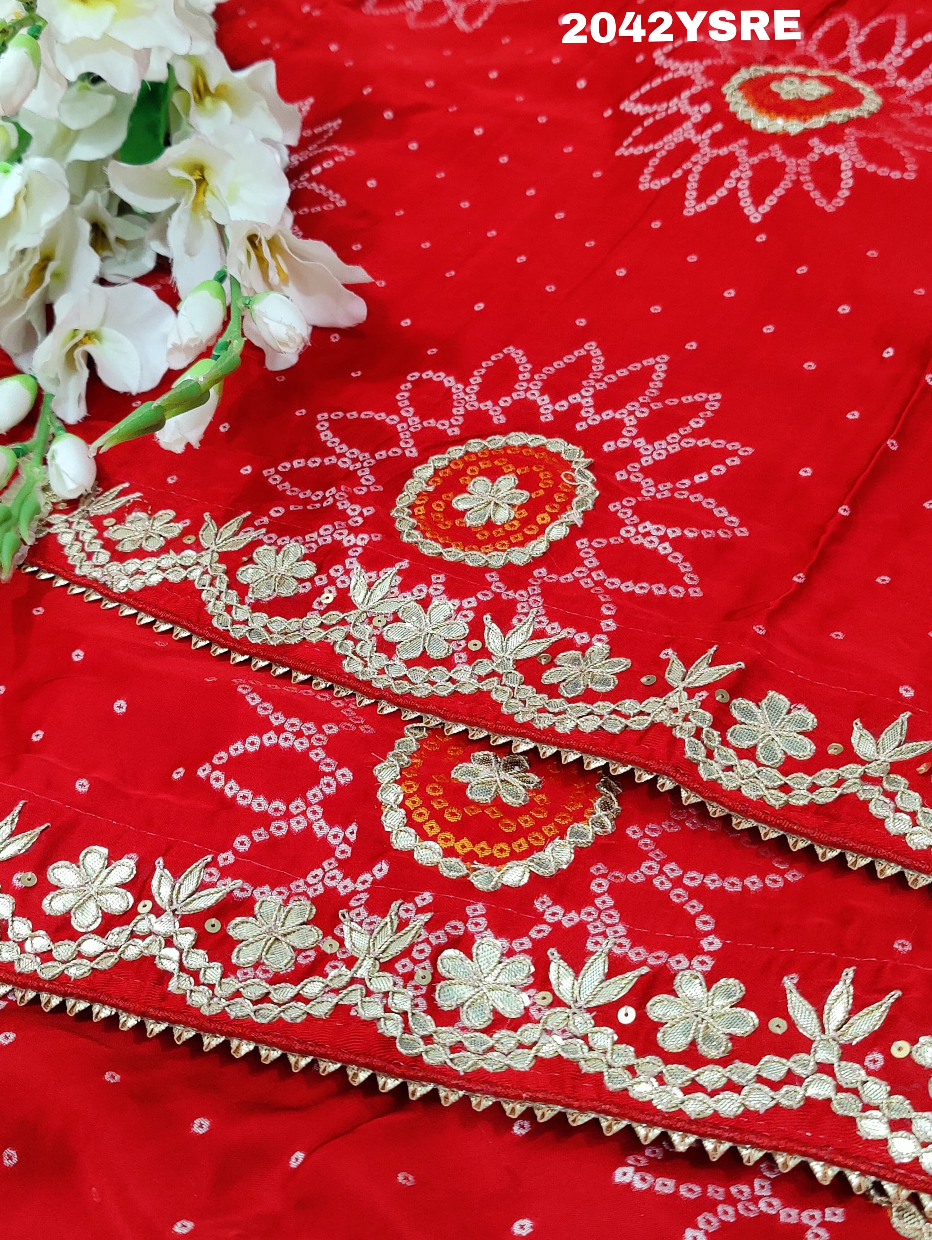 A red and orange bandhani style saree with gota patti work