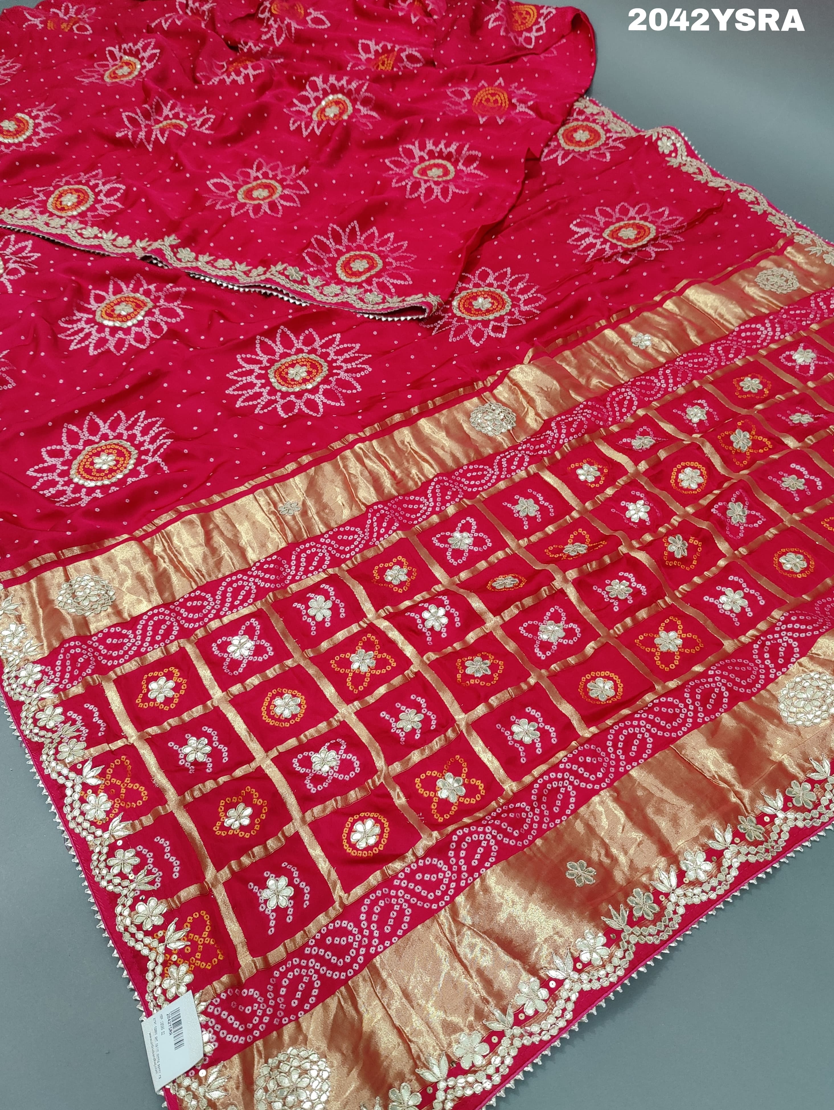 A red and pink silk saree with bandhani style dots and gota patti work