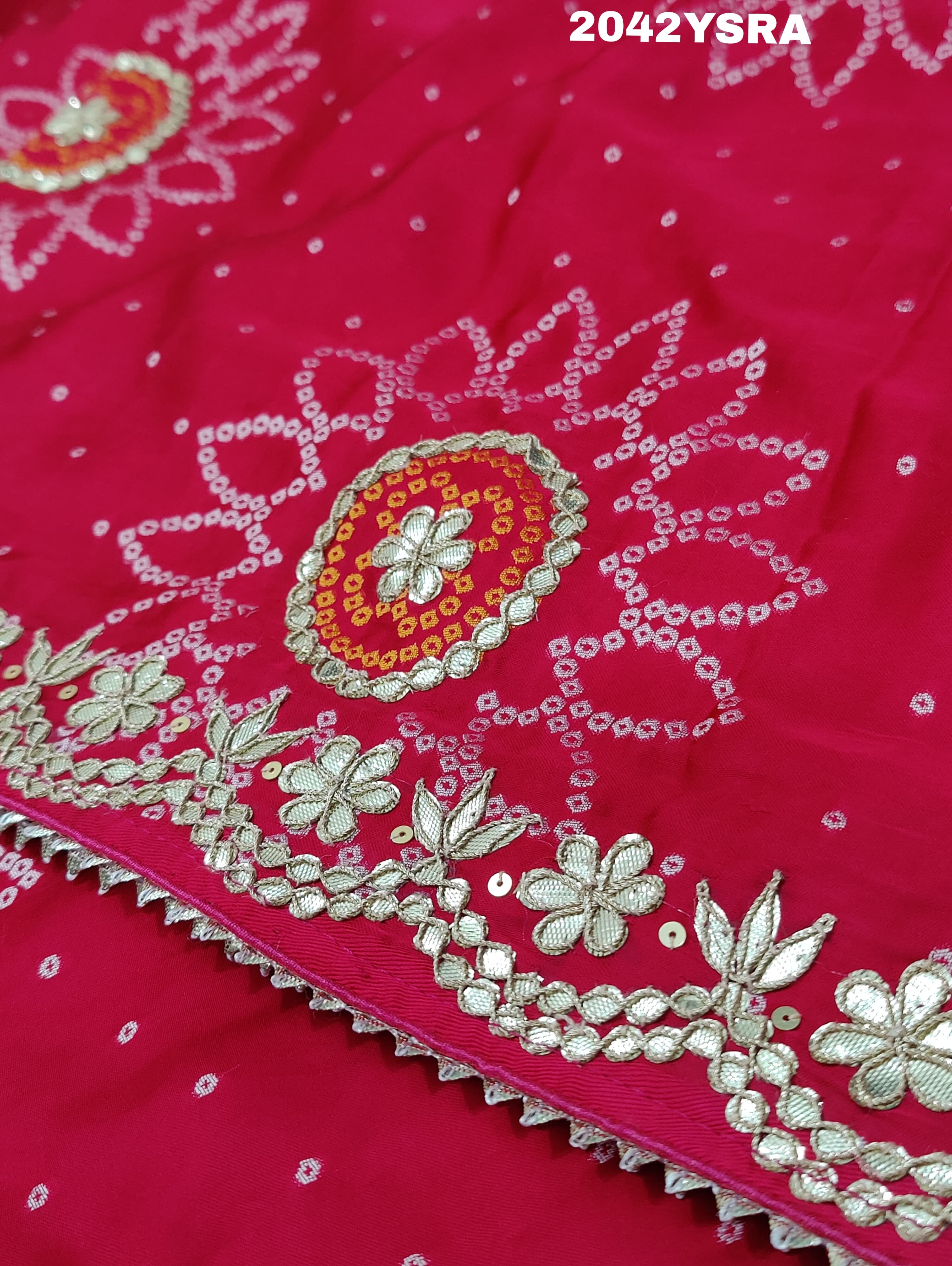A red and pink silk saree with bandhani style dots and gota patti work