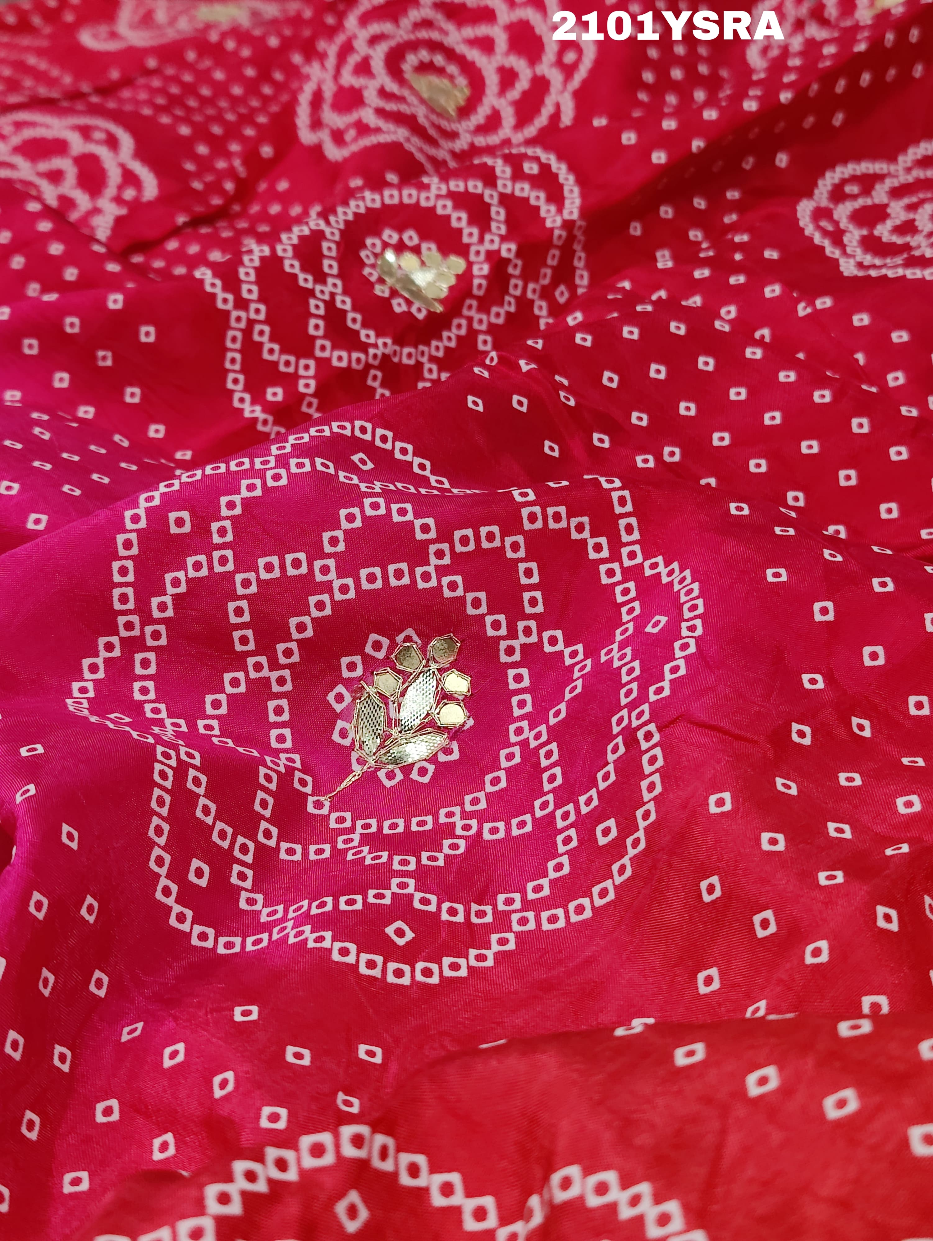 A pink and red traditional Indian saree with floral patterns and gota work.