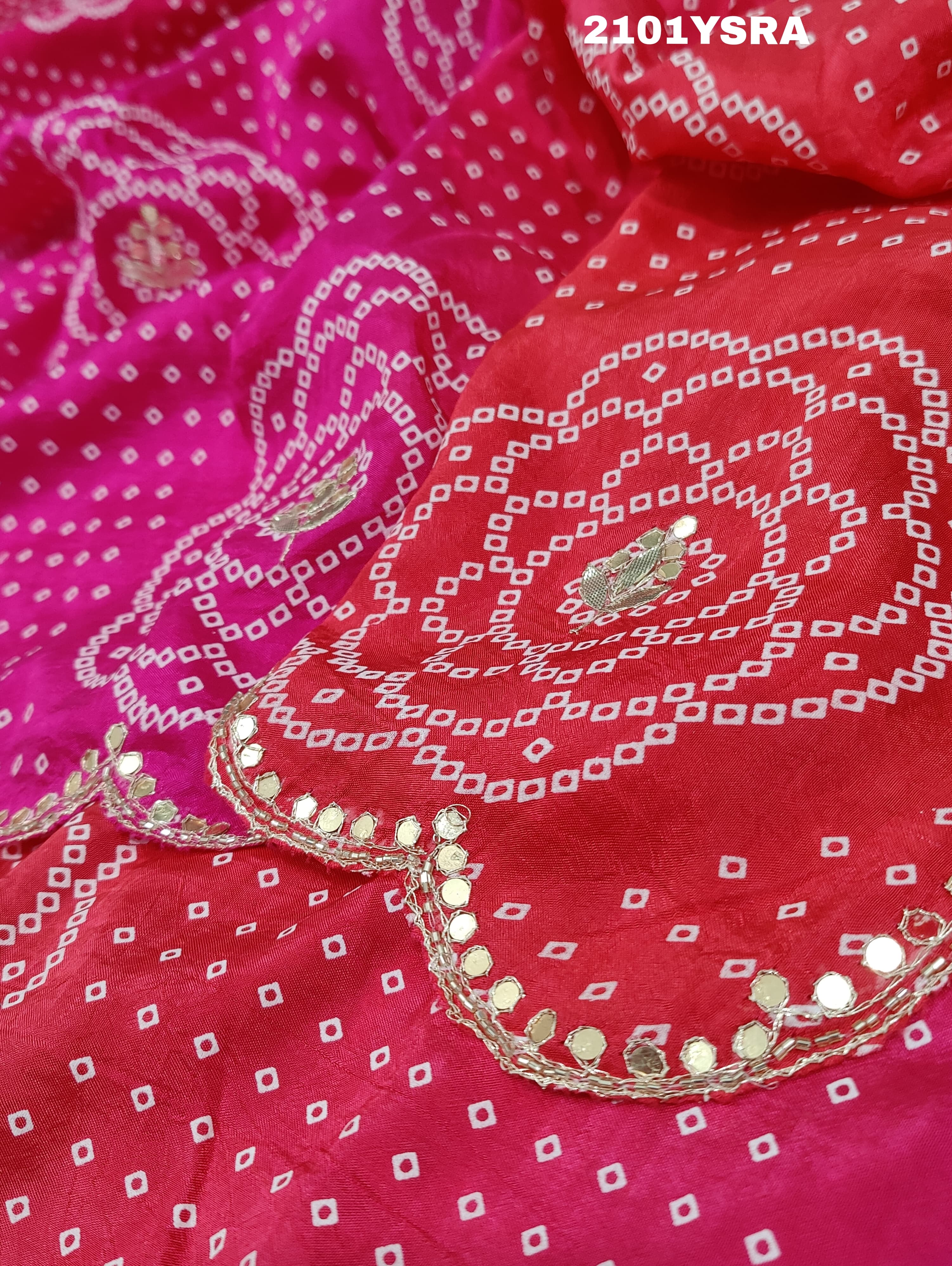 A pink and red traditional Indian saree with floral patterns and gota work.