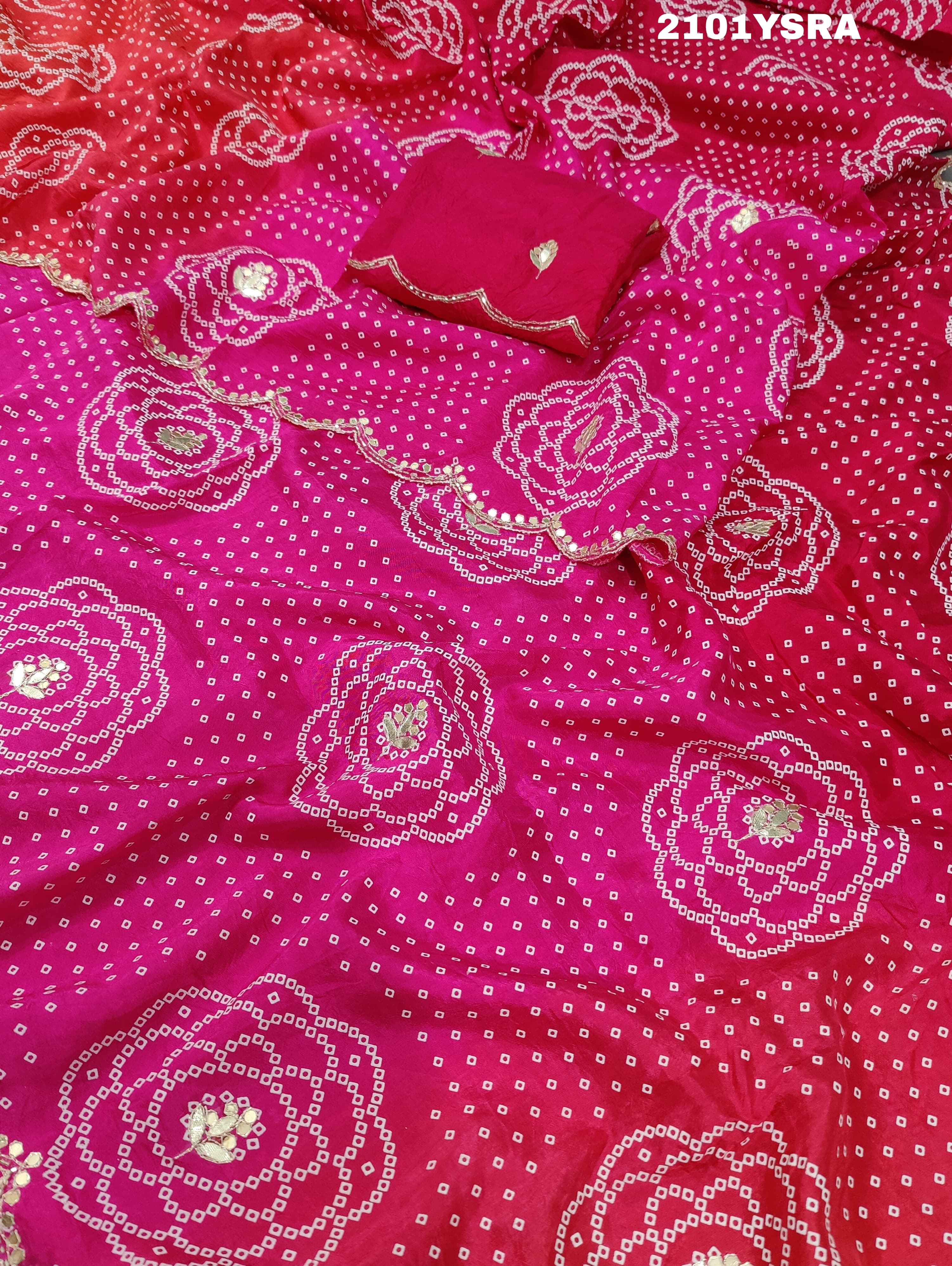 A pink and red traditional Indian saree with floral patterns and gota work.