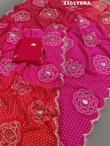 A pink and red traditional Indian saree with floral patterns and gota work.