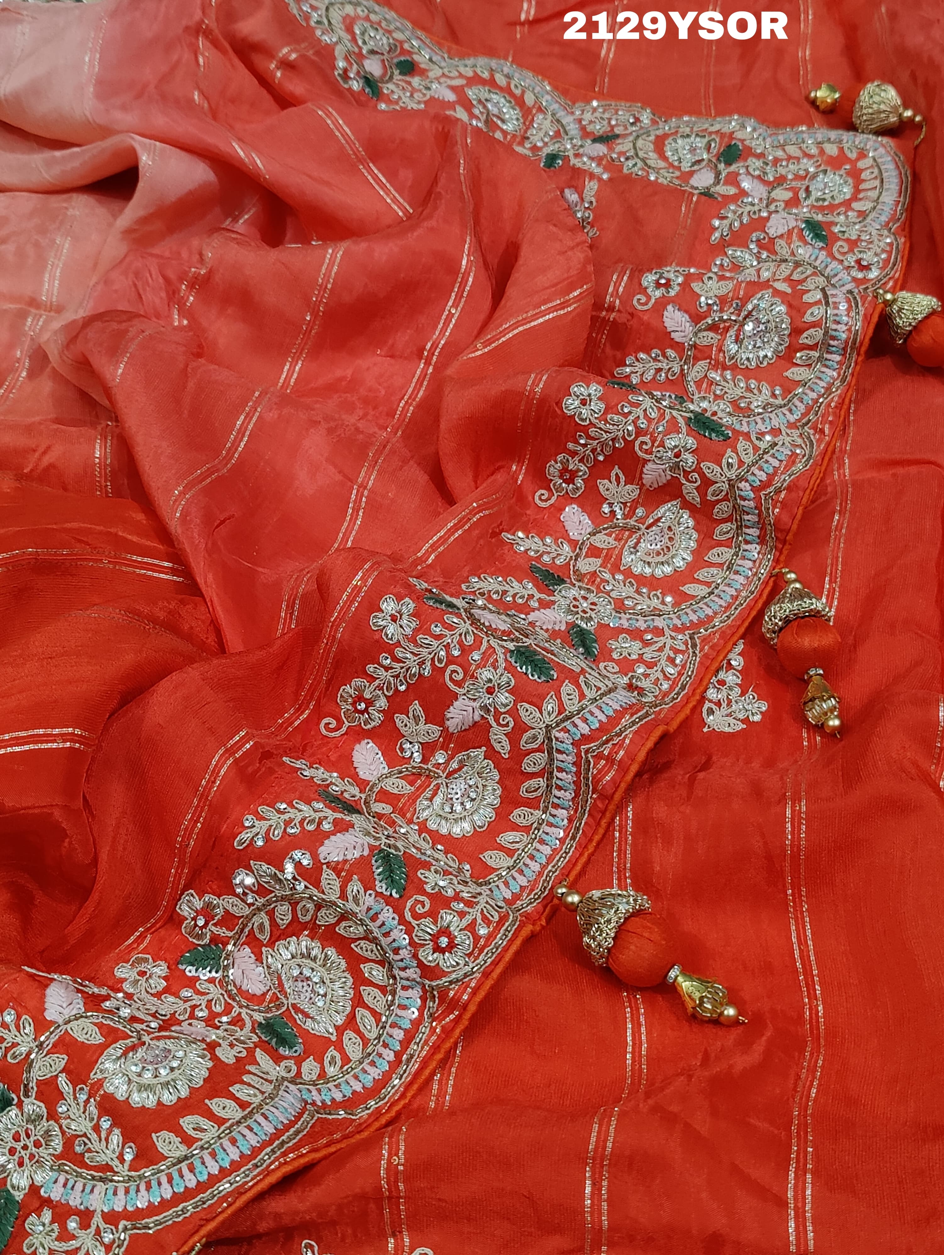 A red saree with silver and gold sequence cutdana work pattern.