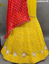 A traditional yellow lehenga with red bandhani style