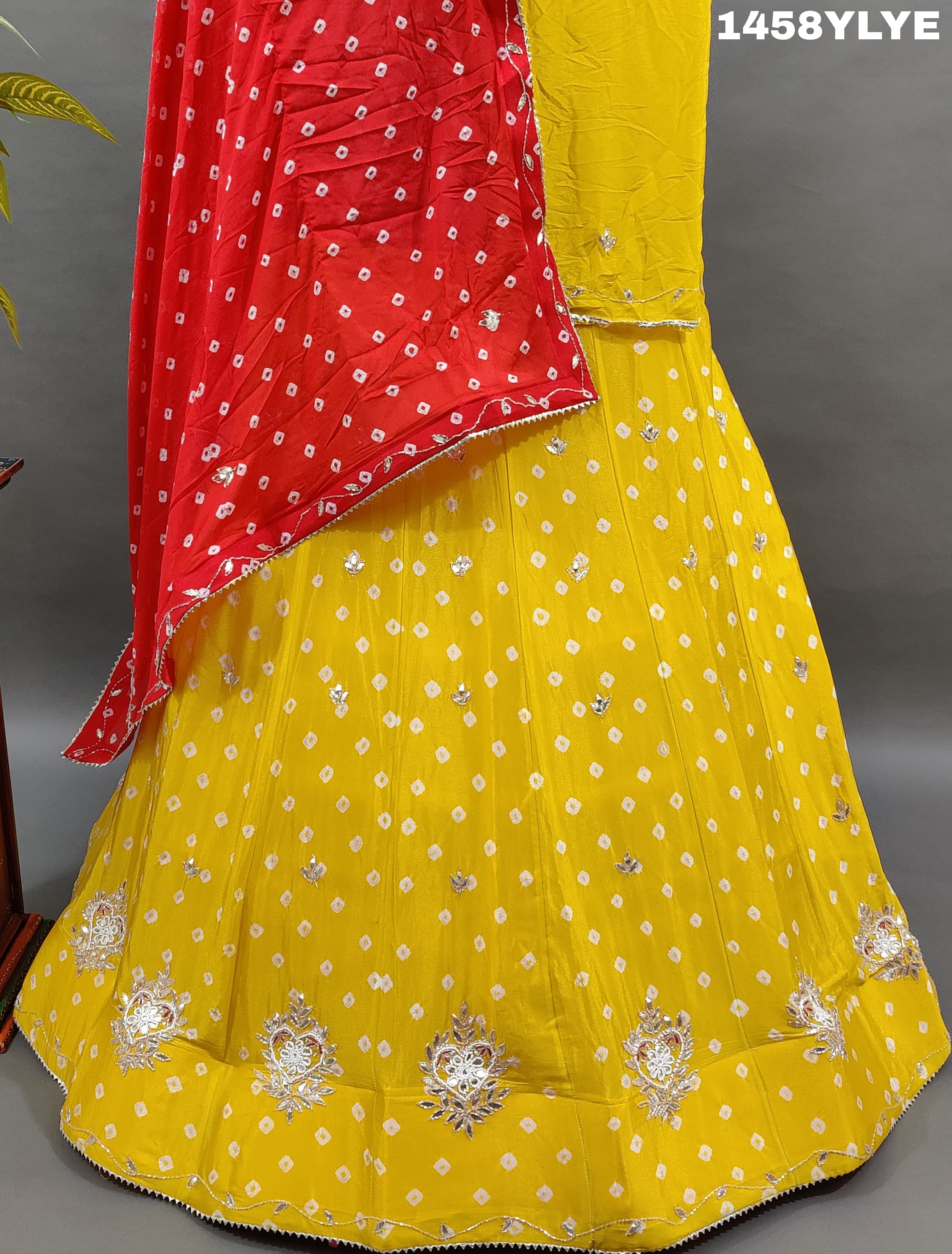 A traditional yellow lehenga with red bandhani style