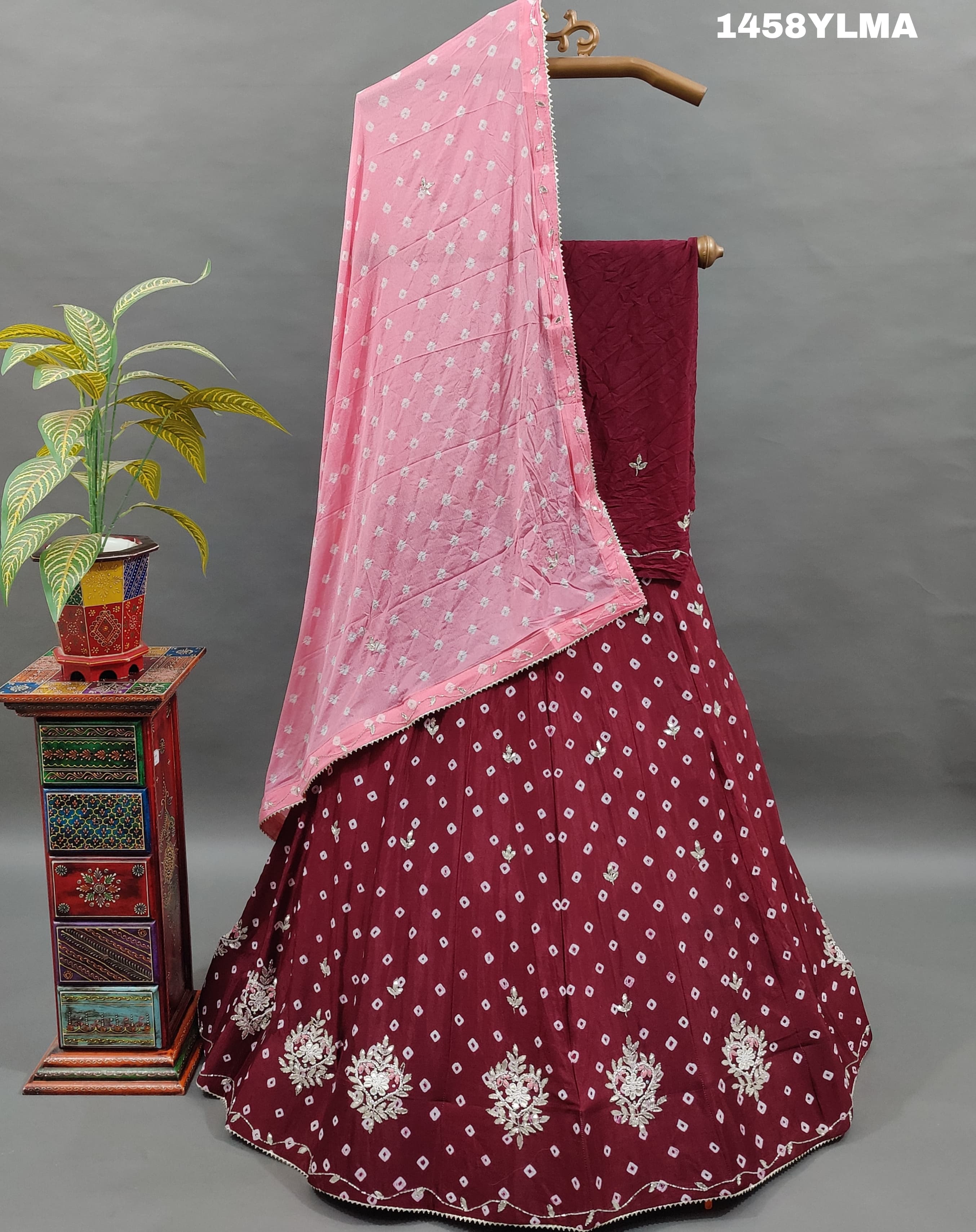 A traditional wear lehenga in maroon color with bandhani style