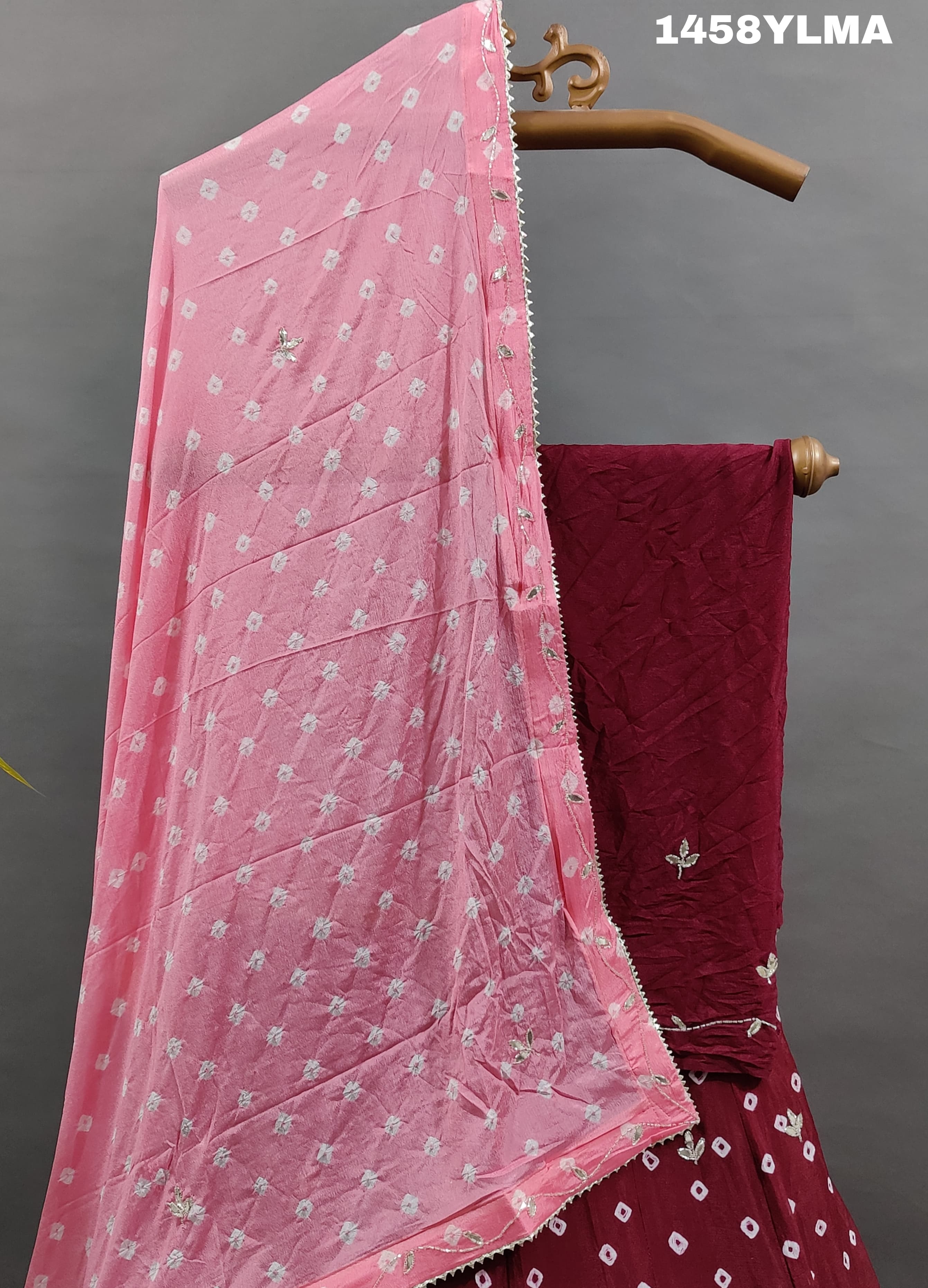 A traditional wear lehenga in maroon color with bandhani style