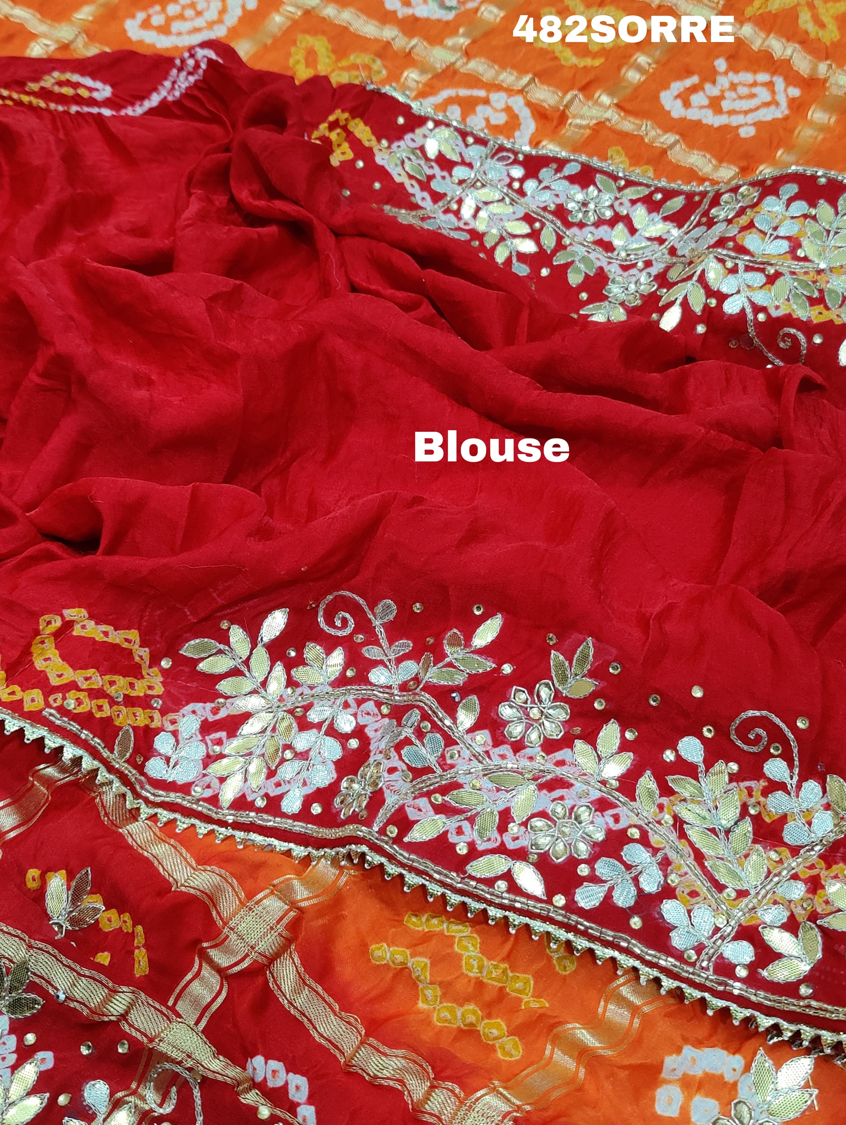 A red and orange pure gaji silk saree with bandhani style embellishments and heavy gotapatti work, along with a golden border and blue details.