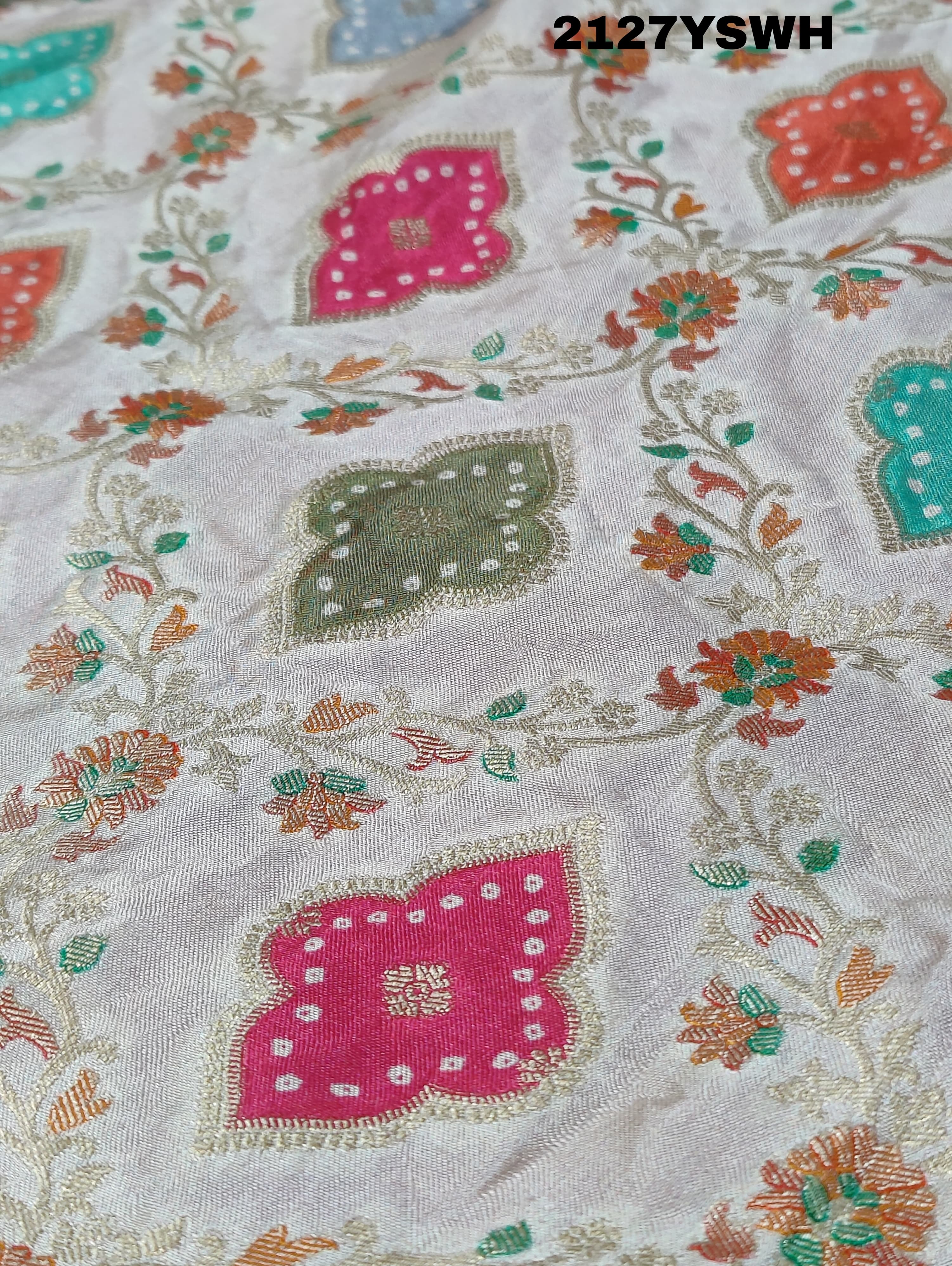 A Banarasi silk saree with a Meenakari pattern featuring a cream body with multicolor floral designs and a red border.